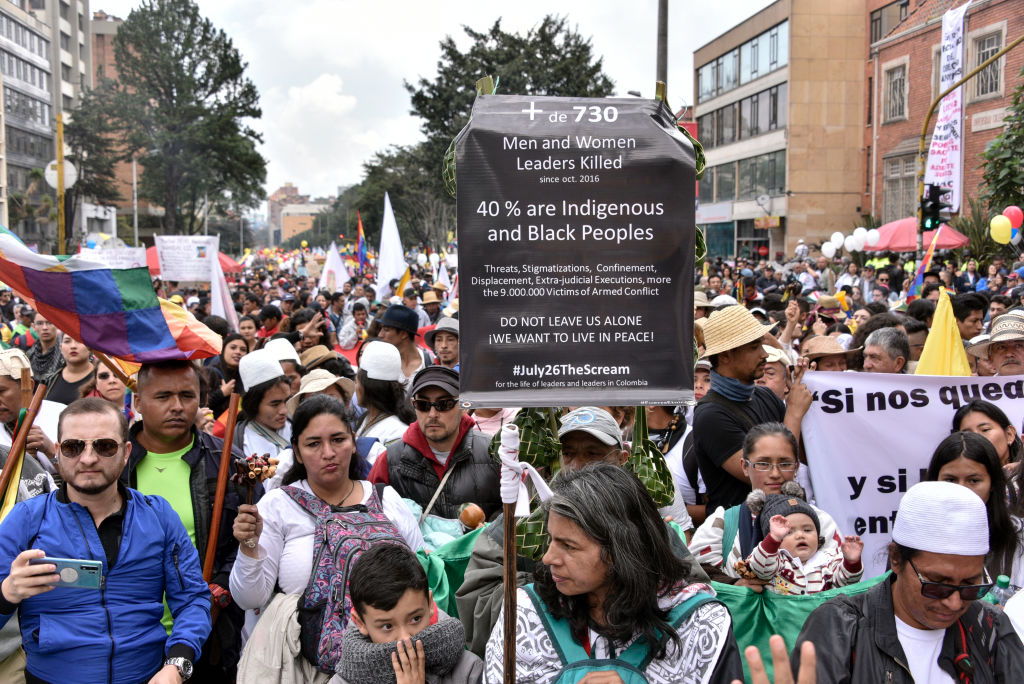 Anti-government demonstrators holding signs during national strike on Nov. 21, 2019 in Bogota, Colombia. (Guillermo Legaria Schweizer—Getty Images)