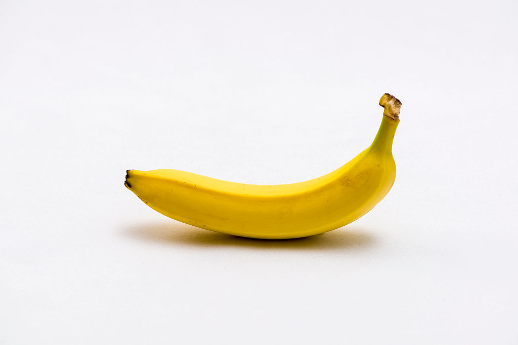 A yellow banana (Musa), displayed on a white table