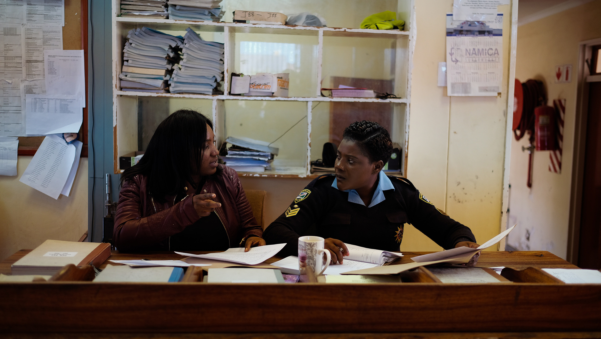 Gender-based Violence Unit Detective Gabriella and Officer Hagatora talk about a possible suspect for a rape case at the Katatura Police Station in Windhoek, Namibia in the summer of 2019. (Asha Stuart/GroundTruth Project)