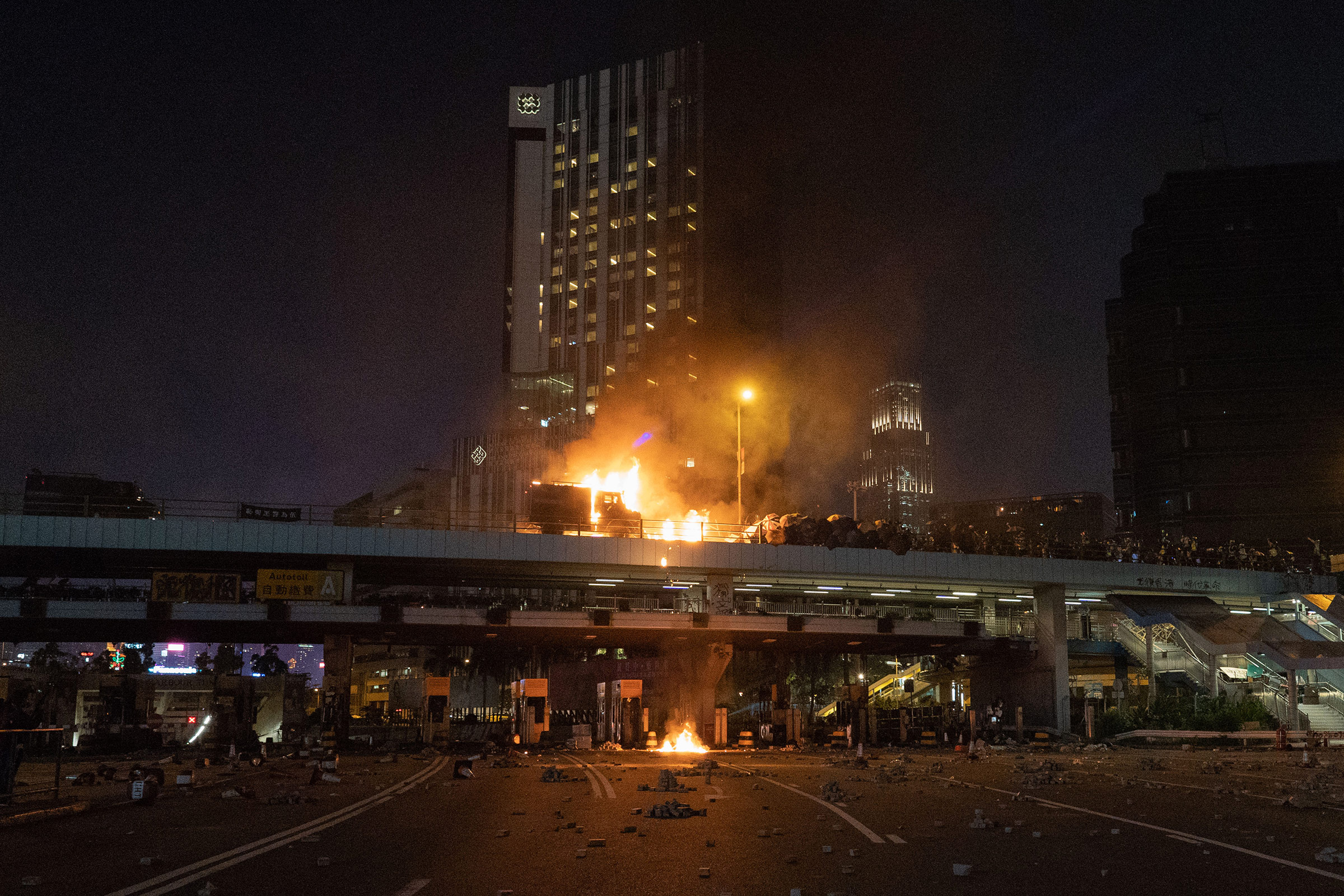 An armored police van is engulfed in flames on a bridge overlooking the Cross-Harbour Tunnel, Nov. 17, 2019.