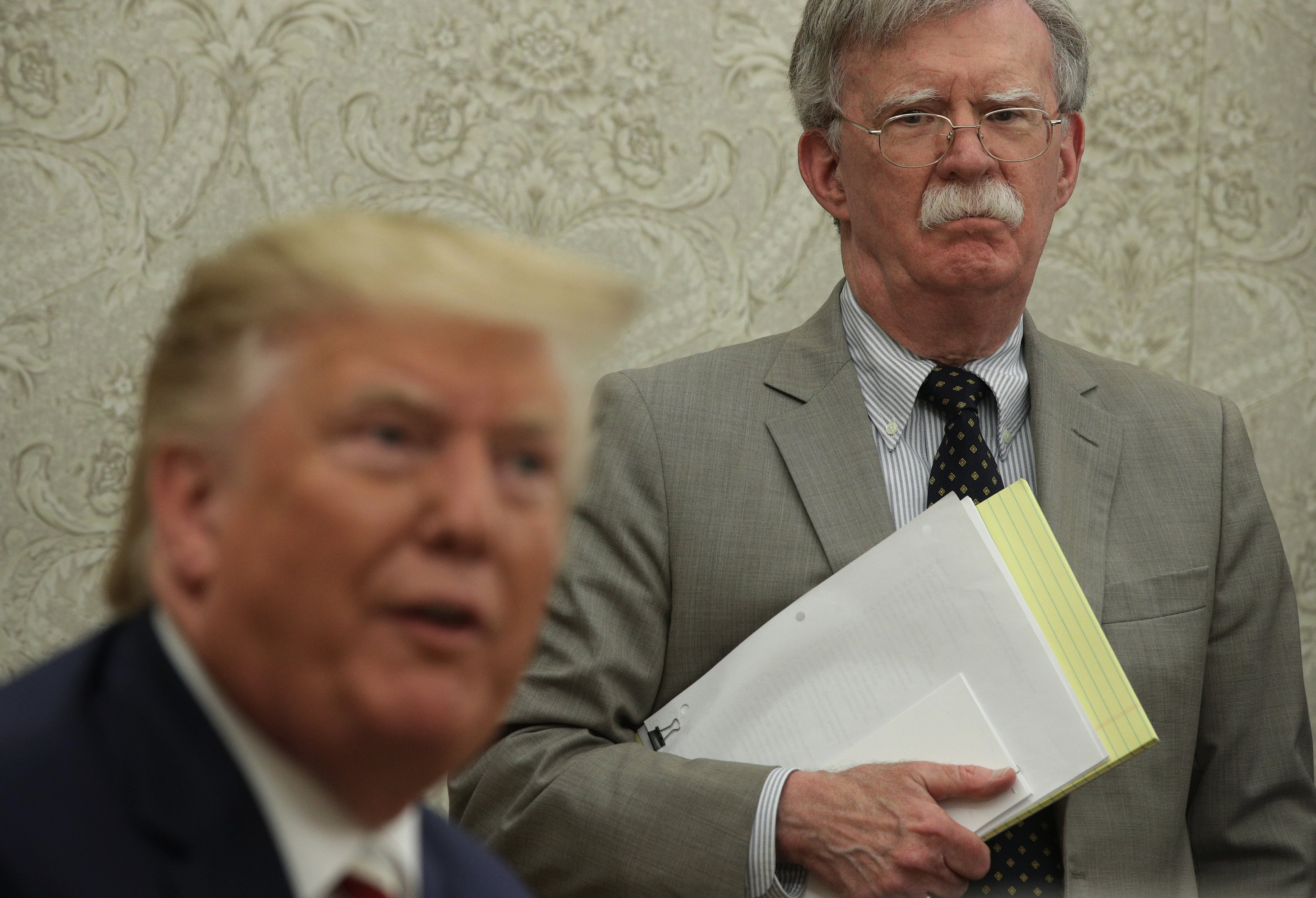 President Donald Trump speaks to members of the media as National Security Adviser John Bolton listens during a meeting with President of Romania Klaus Iohannis in the Oval Office of the White House on Aug. 20, 2019 in Washington, D.C. (Alex Wong&mdash;Getty Images)