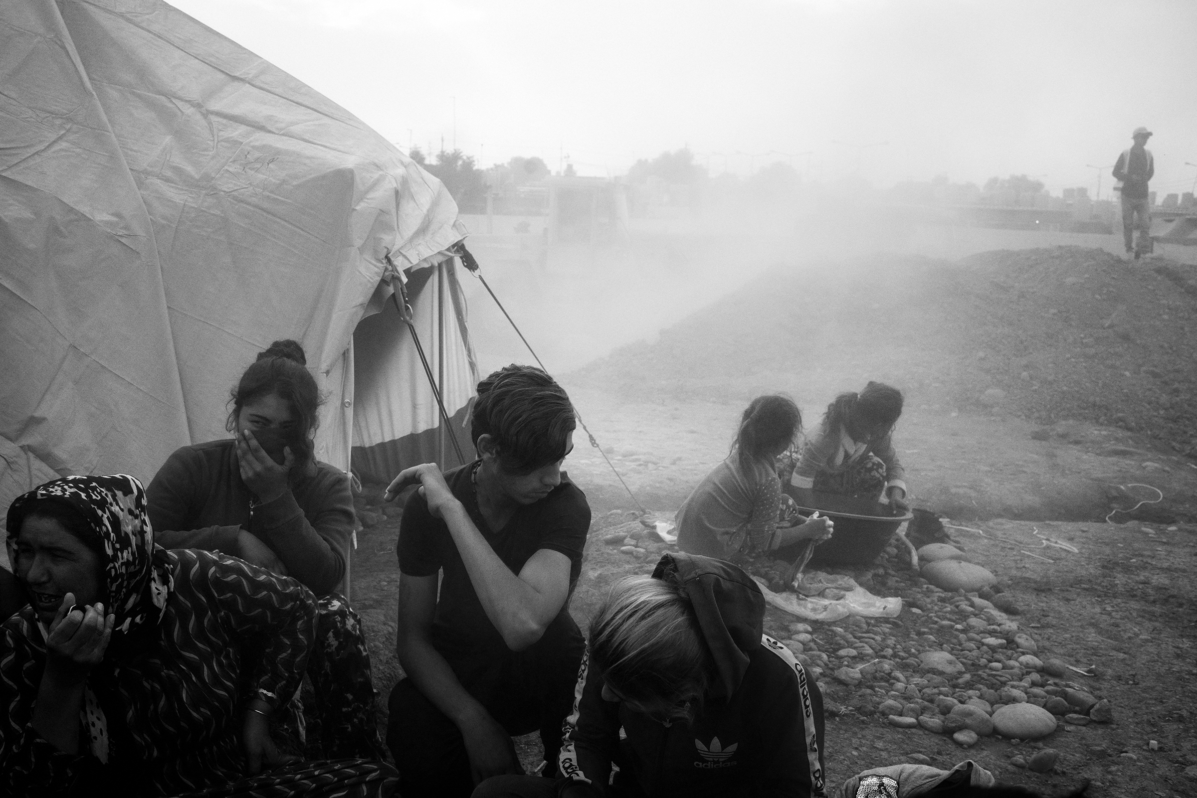A newly arrived refugee family huddles together as dust from ongoing construction lingers in the air at the Gawilan camp in early November. (Moises Saman—Magnum Photos for TIME)