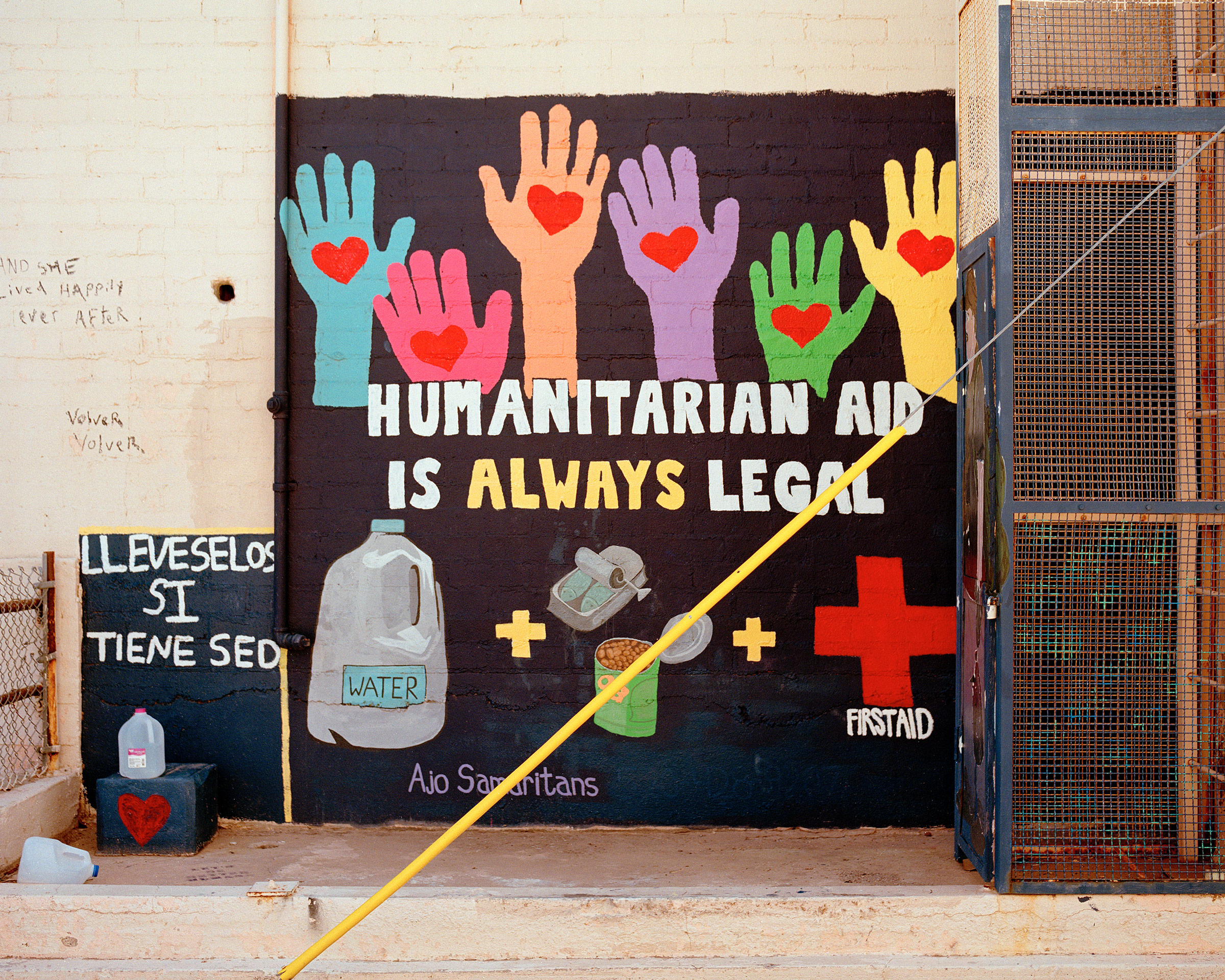 A mural in support of water and food drops is one of dozens in Ajo's "Artist Alley" that depicts support for migrants and the work of humanitarians. "Take them if you're thirsty," is painted in Spanish to the left. (Cassidy Araiza for TIME)