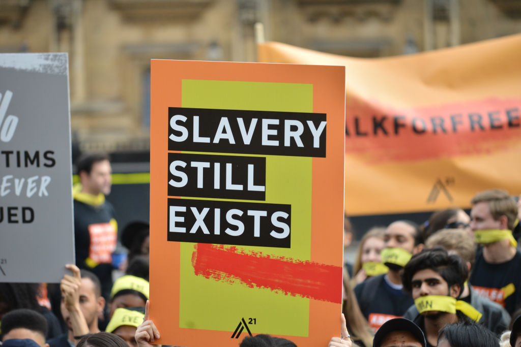 People marching against modern slavery through London wearing face masks representing the silence of modern slaves in forced labour and sexual exploitation on October 14, 2017 in London, England. (Barcroft Media via Getty Images—Mathew Chattle / Barcroft Media)