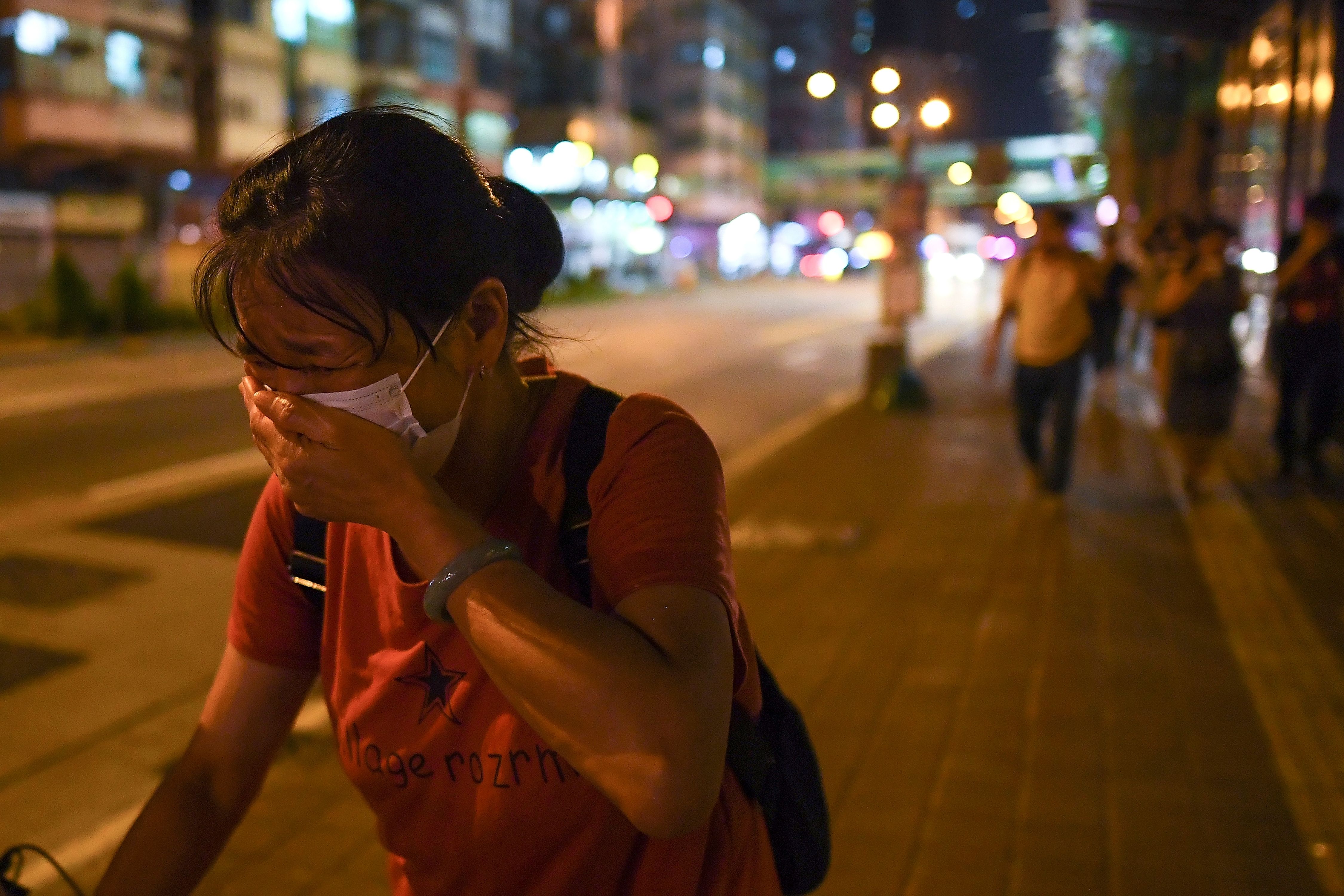 A passerby covers her mouth after police fired tear-gas shells to disperse Pro-Democracy protestors in the Sham Shui Po Area of Hong Kong on August 14, 2019. (MANAN VATSYAYANA&mdash;AFP/Getty Images)