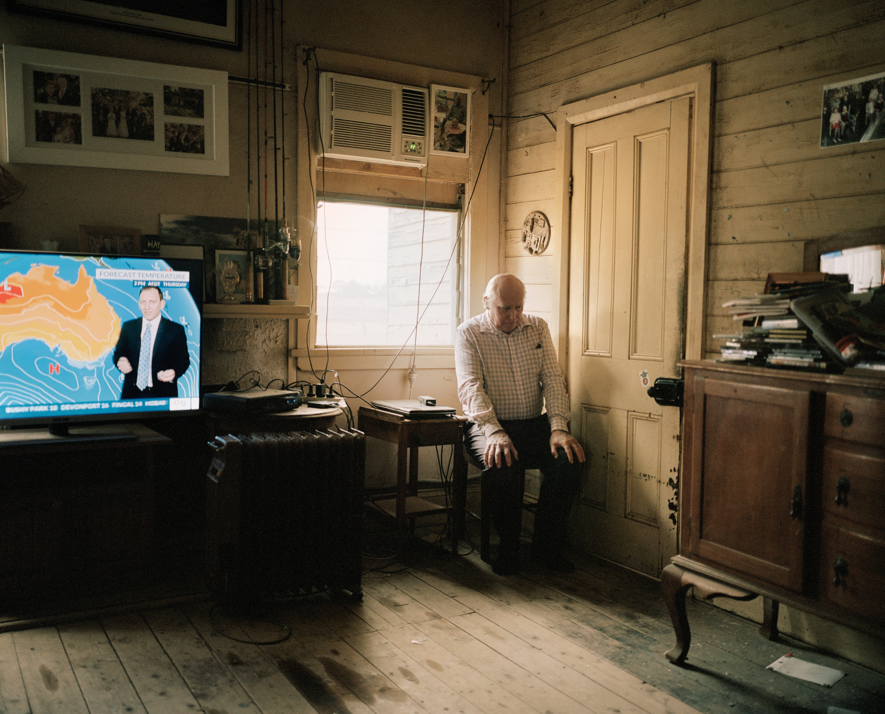 Farmer Jack Slack-Smith, 65, listens to a weather report in his living room on Epping Farm in New South Wales, Australia, in November 2018. The drought has reduced its sheep stock from 7,000 to approximately 3,600, and cattle from 260 breeders to 22. March 4 issue. (Adam Ferguson for TIME)