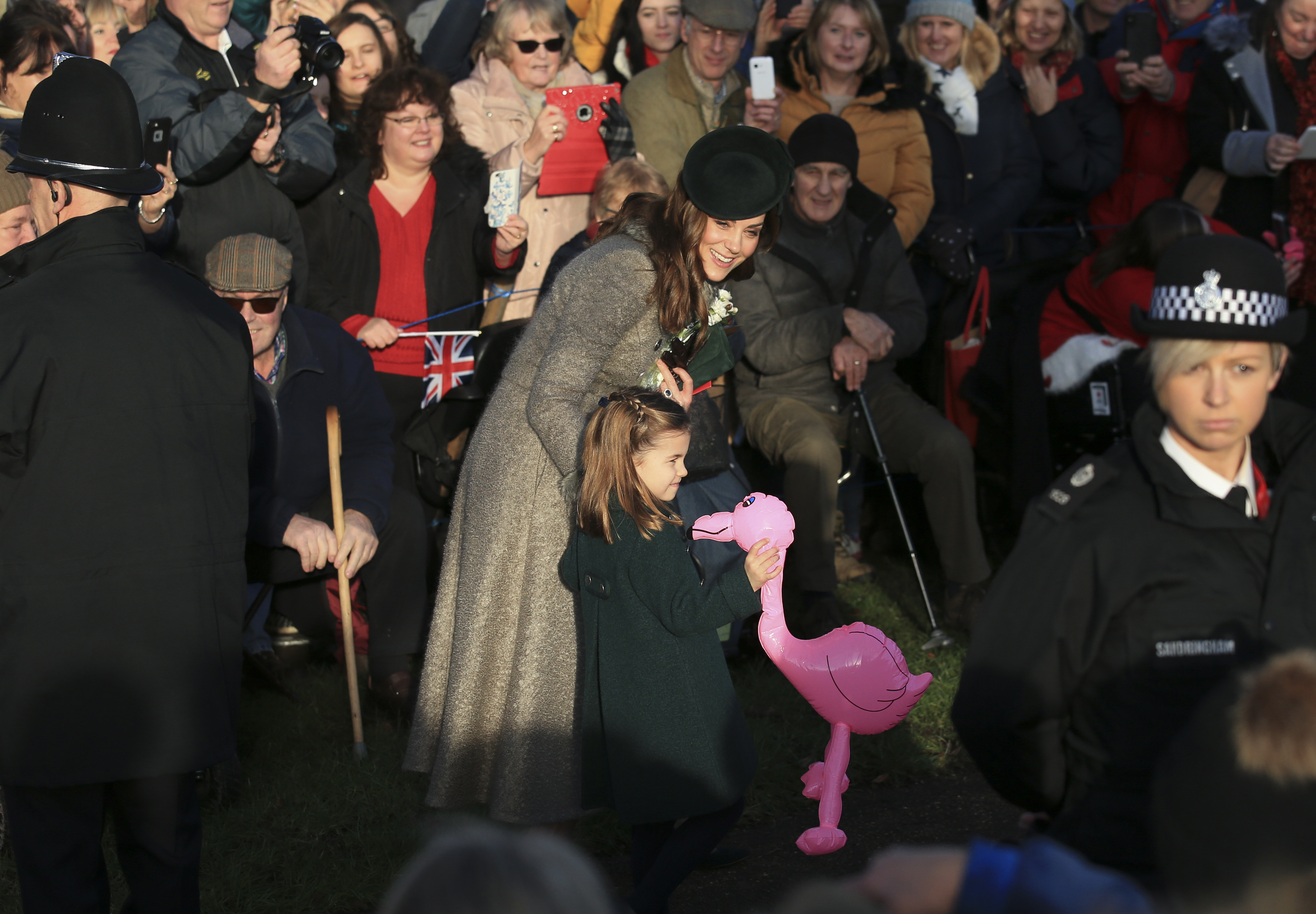 Britain's Catherine, Duchess of Cambridge, center left, speaks with her daughter Princess Charlotte as she holds a pink flamingo while greeting the public outside the St Mary Magdalene Church in Sandringham in Norfolk, England, Wednesday, Dec. 25, 2019. (Jon Super—AP)
