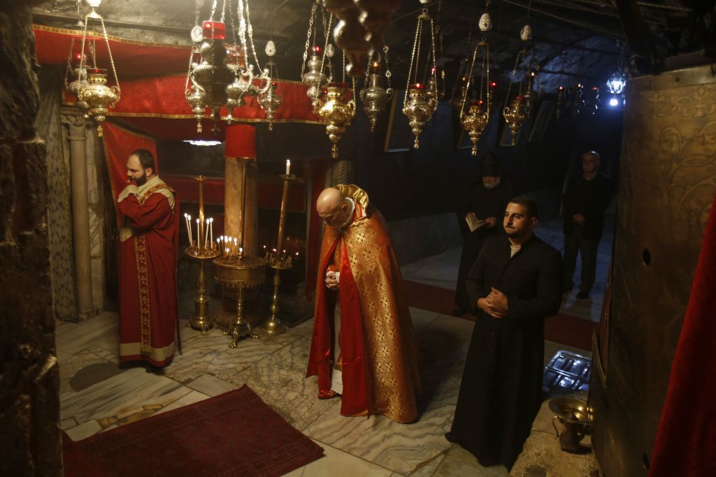 Priests pray in the Grotto of the Church of the Nativity, the site where Christians believe Jesus was born, in the West Bank holy city of Bethlehem on December 18, 2019. (Musa Al Shaer—AFP via Getty Images)