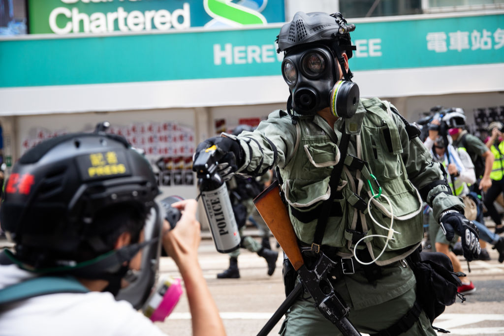 A riot police officer aims pepper spray at a journalist during a protest in Hong Kong on Sept. 29, 2019. (Kyle Lam&mdash;Bloomberg/Getty Images)