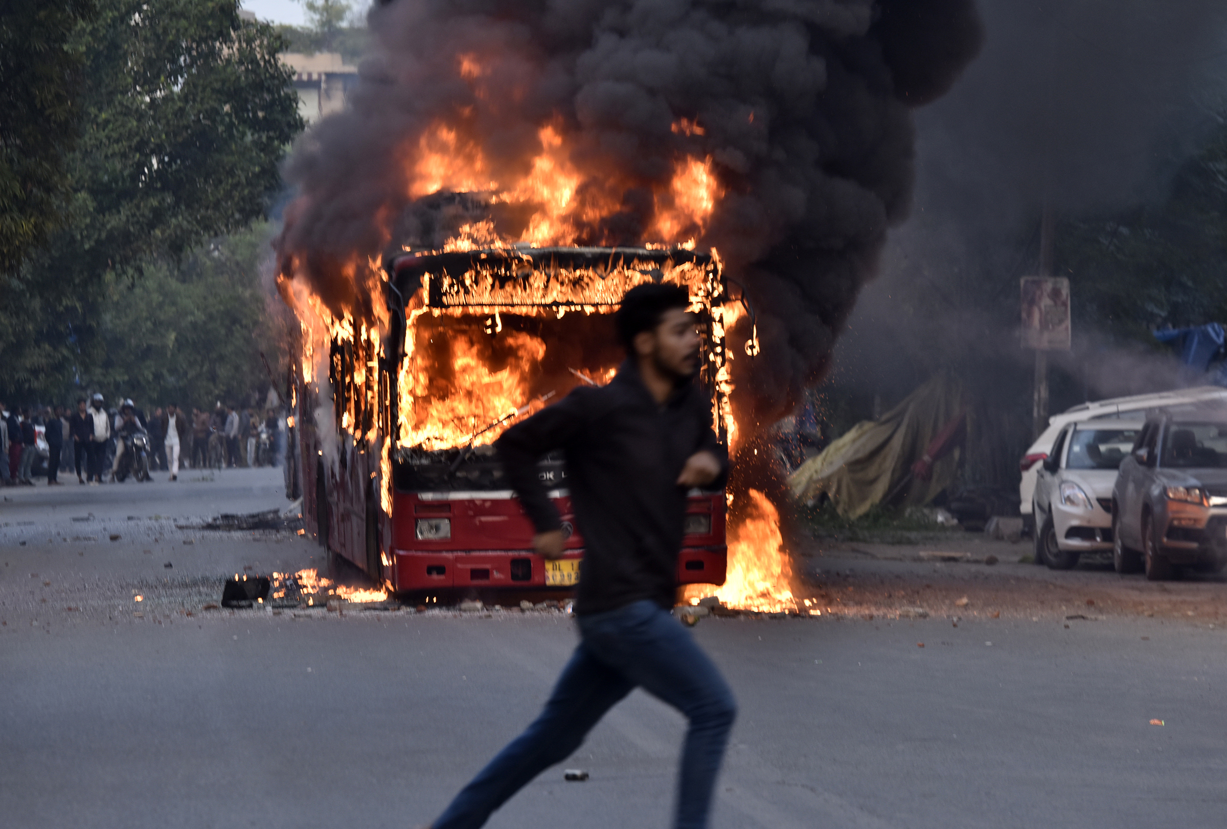 A burning bus is seen after it was set on fire by demonstrators during a protest against the Citizenship amendment Act (CAA) at New Friends Colony in New Delhi, India on Dec. 15, 2019. (Sanjeev Verma—Hindustan Times via Getty Images)