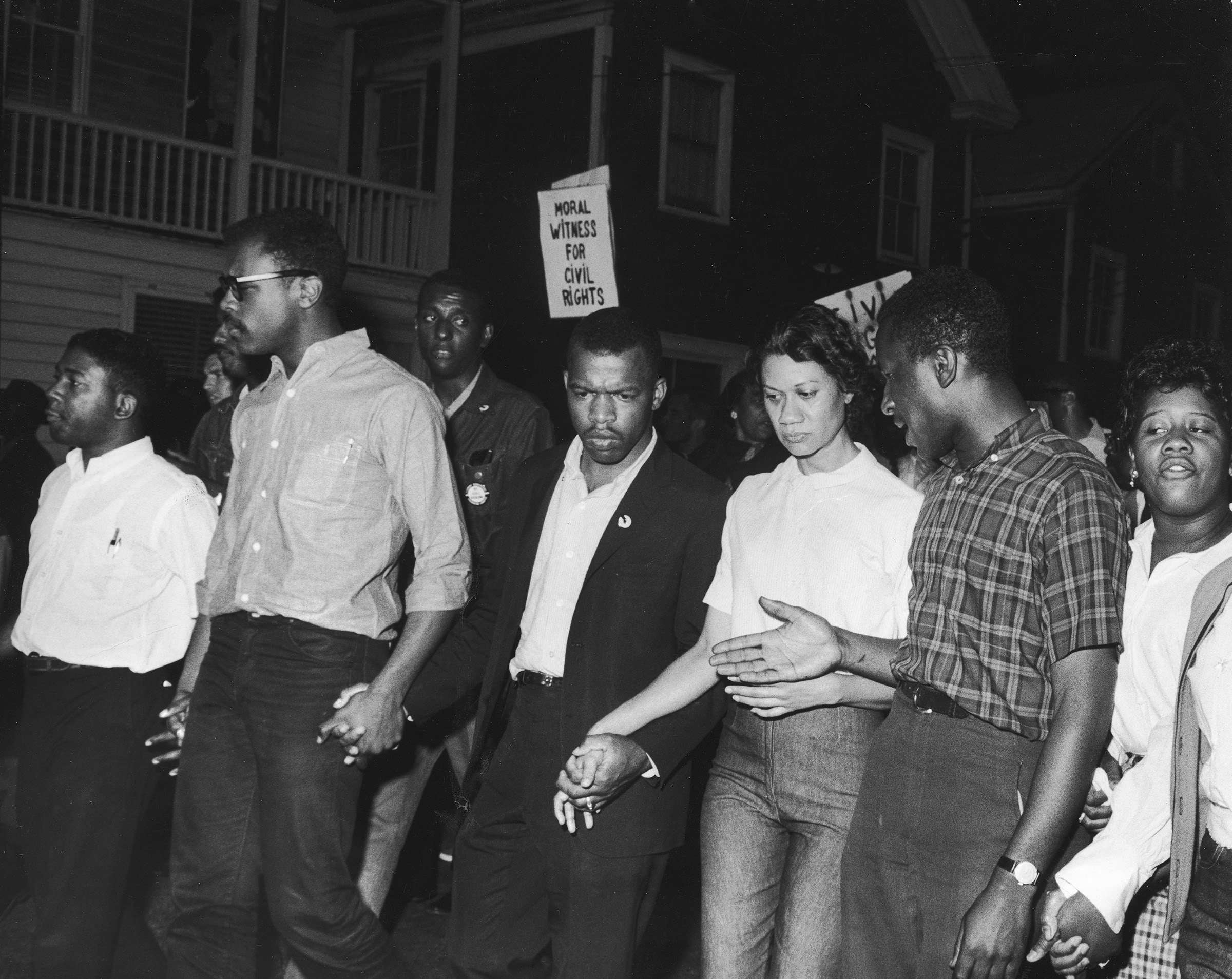 Civil Rights leaders, including future Congressman John Lewis (third left) and Gloria Richardson (third right), chair of the Cambridge Non-Violent Action Committee, link hands as they march in protest of a scheduled speech by the pro-segregationist Alabama governor, George Wallace in Cambridge, Md., in May 1964. (Francis Miller—The LIFE Picture Collection via Getty Images)