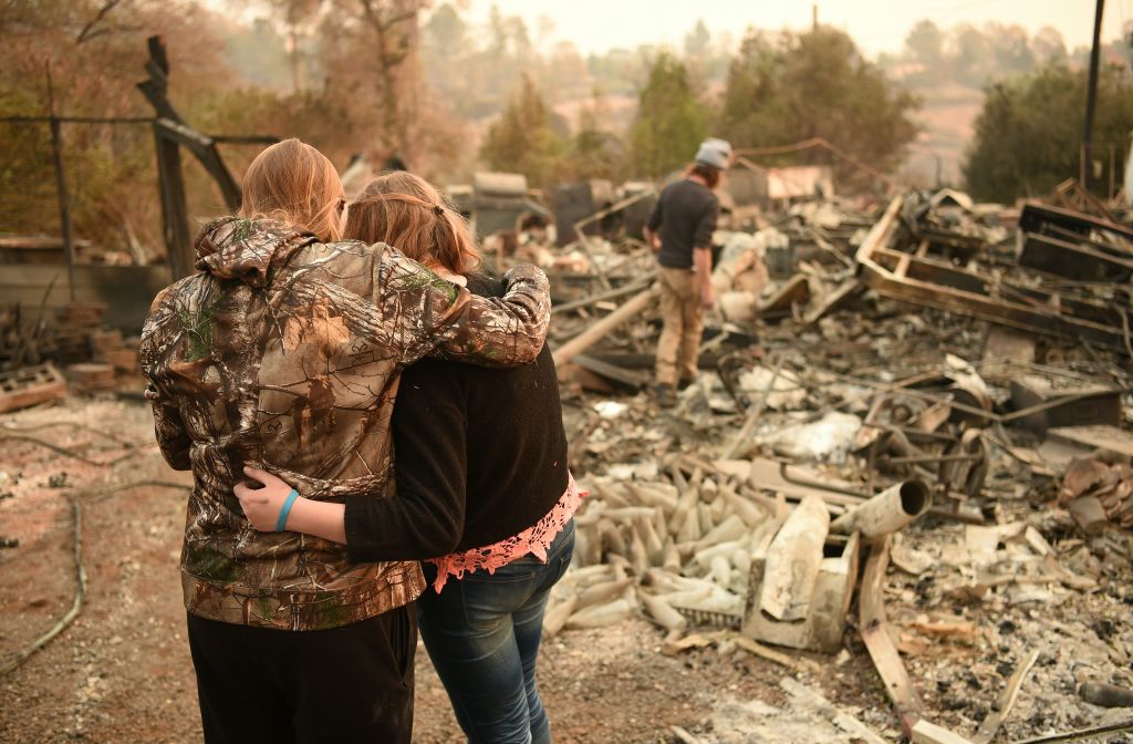 Kimberly Spainhower hugs her daughter Chloe, 13, while her husband Ryan Spainhower (R) searches through the ashes of their burned home in Paradise, California on Nov. 18, 2018. (Josh Edelson&mdash;AFP/Getty Images)