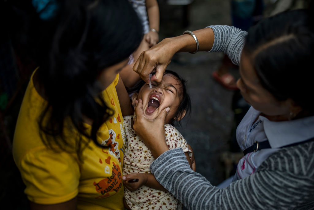 A community health worker administers an oral polio vaccine to a child in Manila, Philippines on Oct. 14, 2019. (Ezra Acayan&mdash;Getty Images)