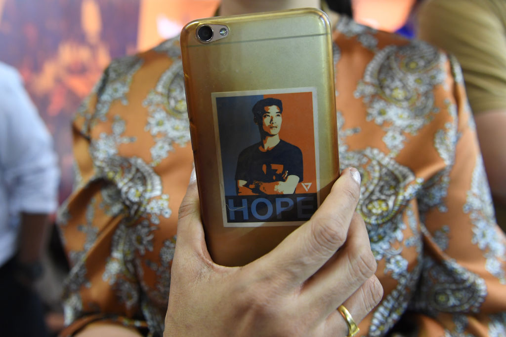 A woman holds a mobile phone decorated with a sticker featuring an image of Future Forward Party leader Thanathorn Juangroongruangkit during the party's press conference in Bangkok on March 25, 2019 after Thailand's general election. (Lillian Suwanrumpha–AFP/Getty Images)