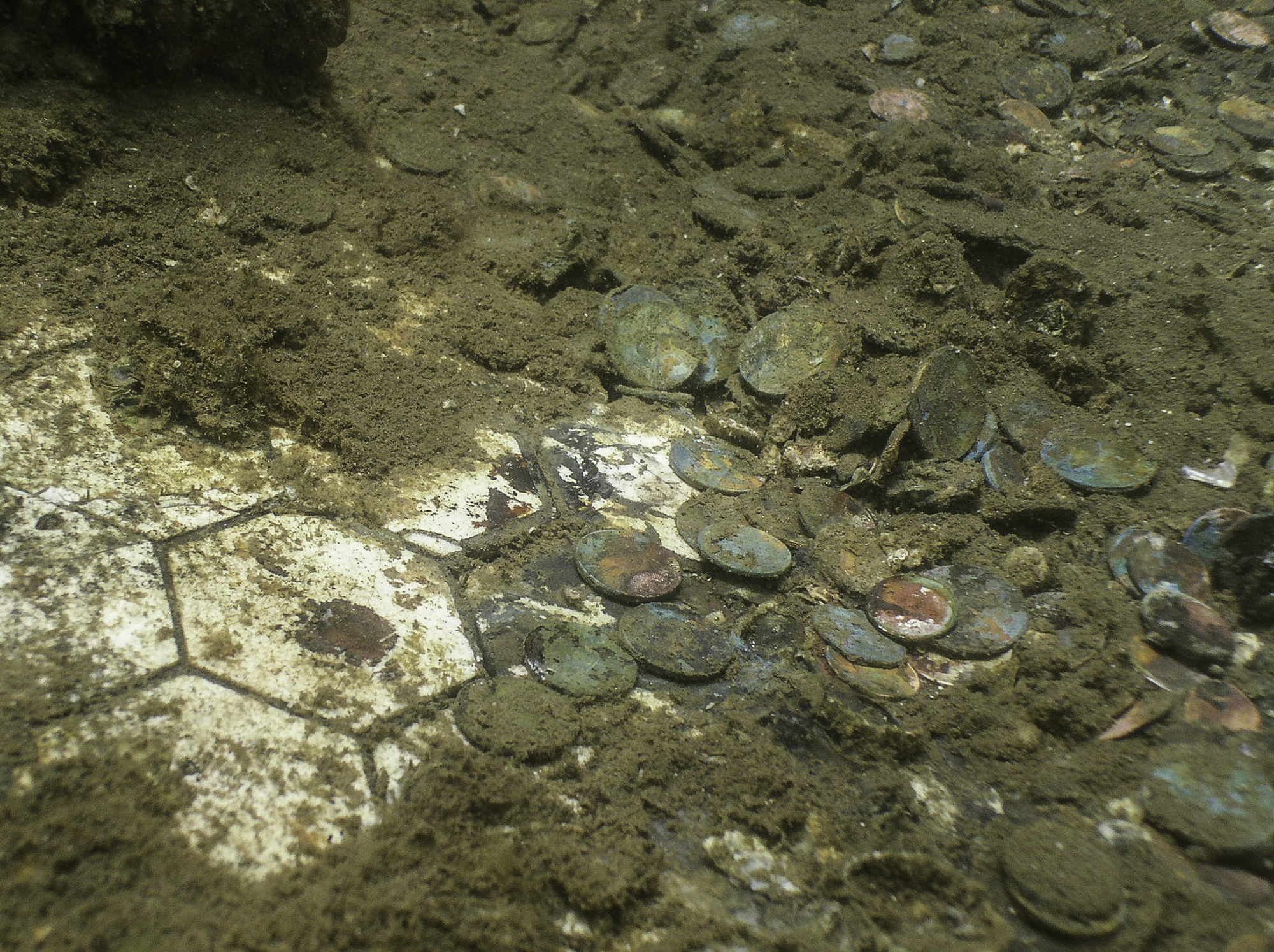 Coins from many nations rest on the white galley floor tiles directly beneath the U.S.S. <em>Arizona</em>'s memorial. (Brett Seymour/Submerged Resources Center)