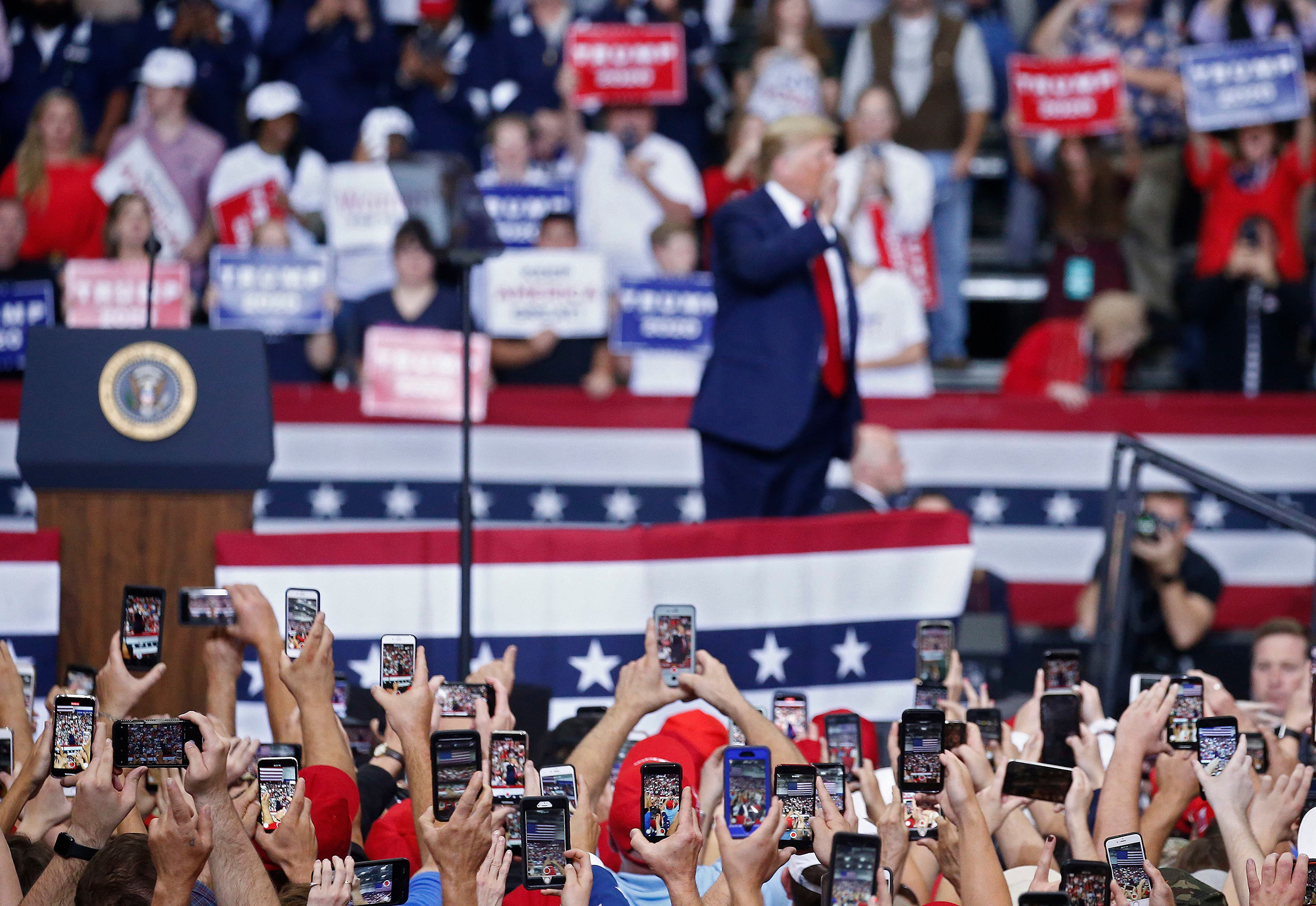 People use their phones to photograph President Donald Trump as he addresses a rally in Monroe, La., on Nov. 6 (Larry W. Smith—EPA-EFE/Shutterstock)