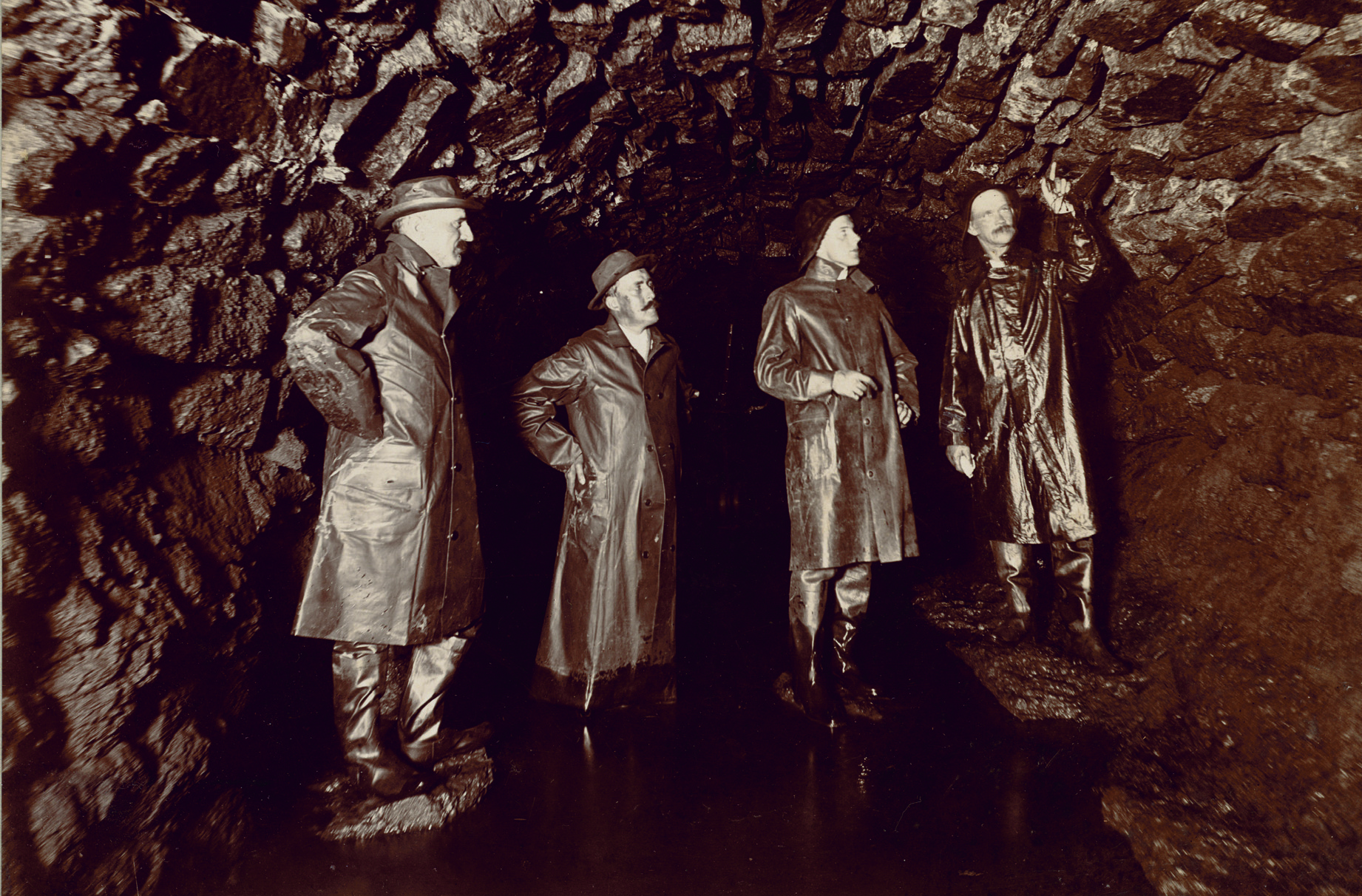 Men examining sewer stone work