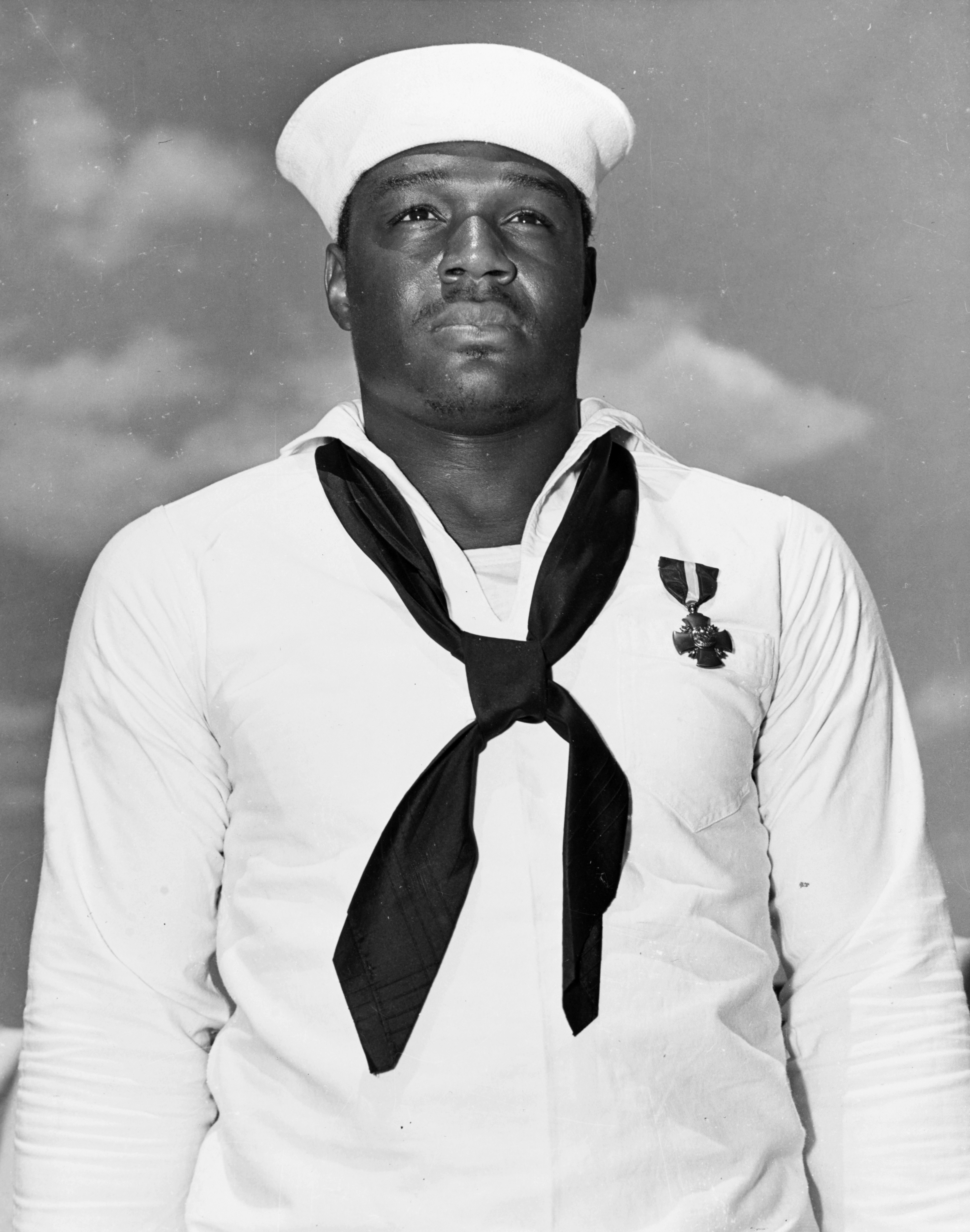 (Jan. 17, 2020) In this file photo taken May 27, 1942, Mess Attendant 2nd Class Doris Miller stands at attention after being awarded the Navy Cross medal for for his actions aboard the battleship USS West Virginia (BB-48) during the Dec. 7, 1941 Japanese attack on Pearl Harbor. The medal was presented to Miller by Adm. Chester Nimitz aboard the aircraft carrier USS Enterprise (CV-6) during a ceremony in Pearl Harbor, Hawaii. (U.S. Navy)