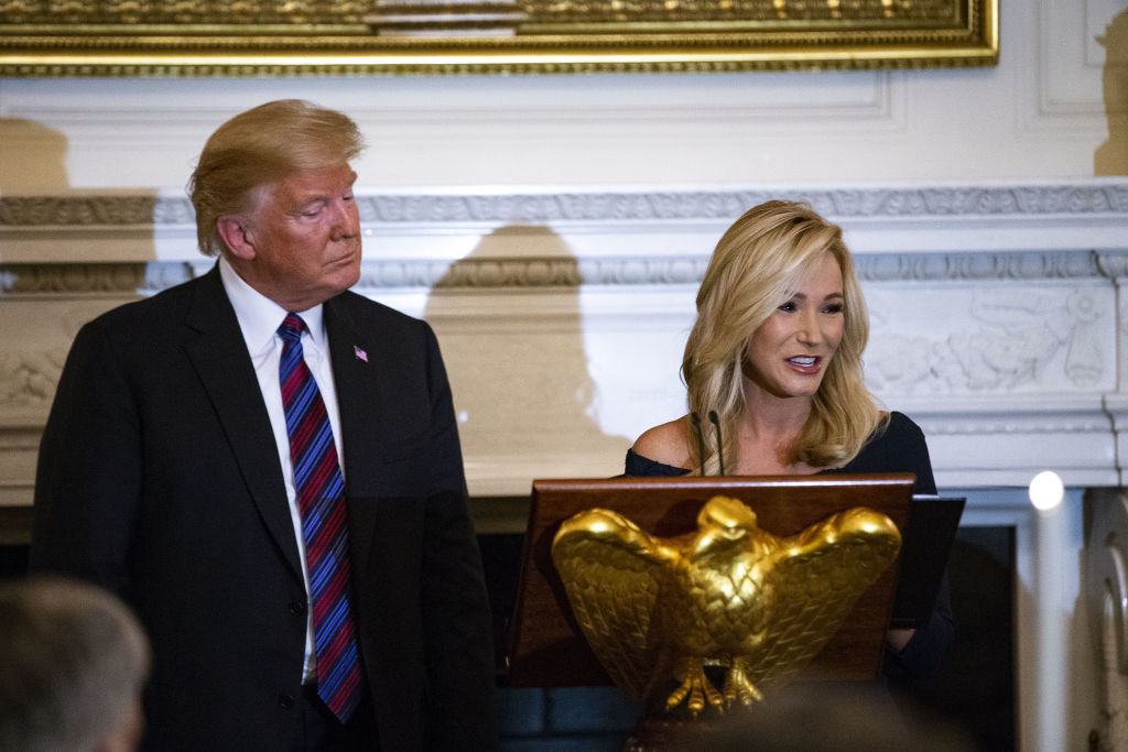 Pastor Paula White leads a prayer beside U.S. President Donald Trump during a dinner celebrating Evangelical leadership in the State Dining Room of the White House in Washington, D.C., on Aug. 27, 2018. (Al Drago—Bloomberg via Getty Images)