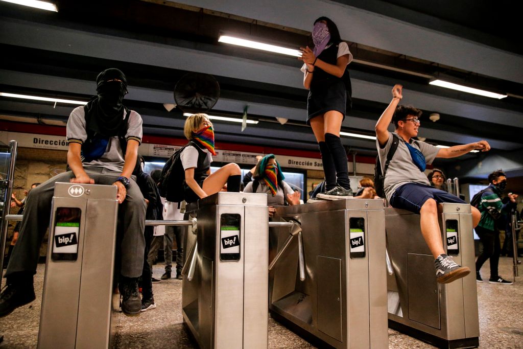 Students demonstrate at Los Heroes metro station during a mass fare-dodging protest in Santiago, Chile, on December 02, 2019. (Javier Torres – AFP/Getty Images)
