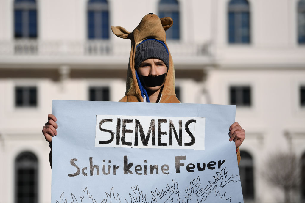 A supporter of the Fridays for Future movement dressed in a kangaroo costume holds a poster reading "Siemens, don't rake fire" during a protest outside the corporate headquarters of German engineering conglomerate Siemens AG on January 10, 2019 in Munich, Germany. The protesters are demanding that Siemens pull out of its participation in the Adani Carmichael coal mine venture in Australia. (Andreas Gebert–Getty Images)