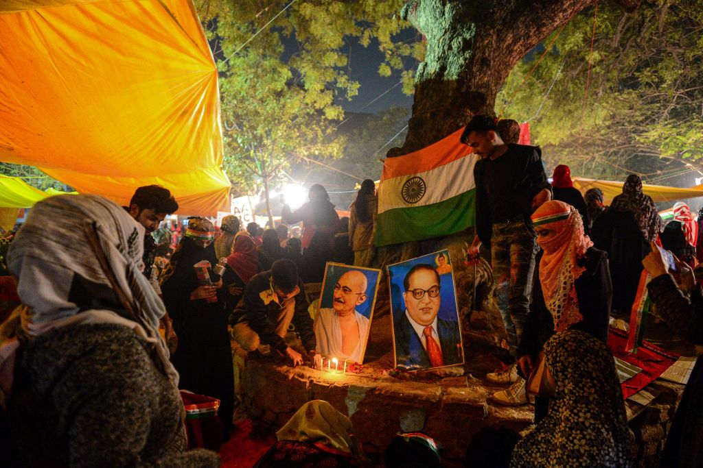 Protesters light candles near posters of Mahatma Gandhi and Bhimrao Ramji Ambedkar during a demonstration against India's new citizenship law in Allahabad (formally known as Prayagraj) on January 14, 2020. (SANJAY KANOJIA/AFP via Getty Images)