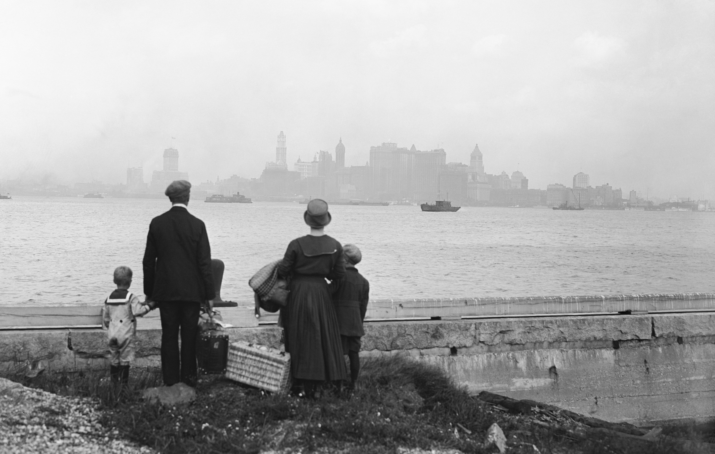 An immigrant family on the dock at Ellis Island, N.Y., looking at New York's skyline while awaiting the ferry to take them there, in 1925. (Bettmann Archive/Getty Images)