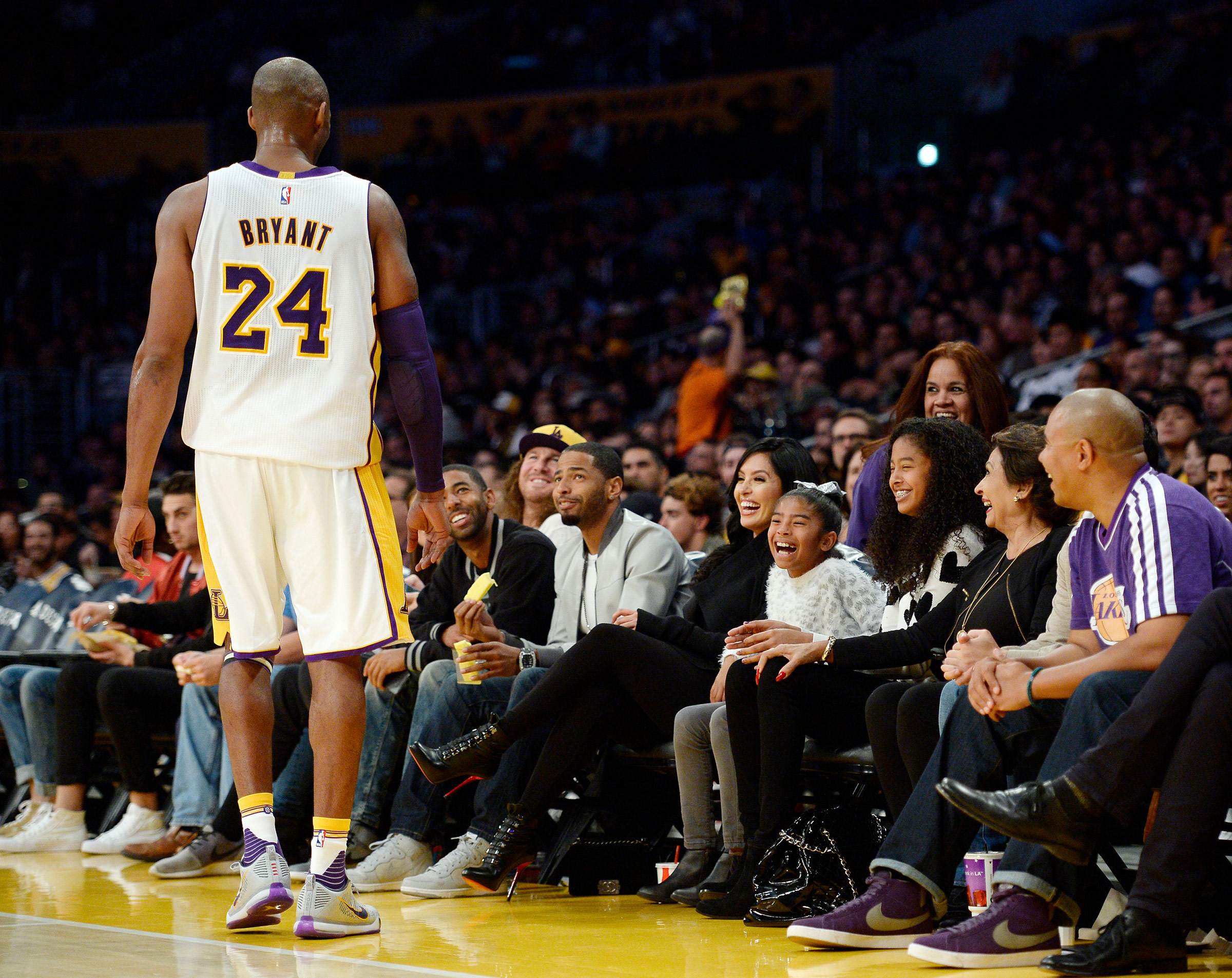 Kobe Bryant of the Los Angeles Lakers speaks with his daughters Gianna, 8, Natalia, 12, and wife Vanessa during the basketball game against the Indiana Pacersin Los Angeles, on Nov. 29, 2015 (Kevork Djanzesian—Getty Images)