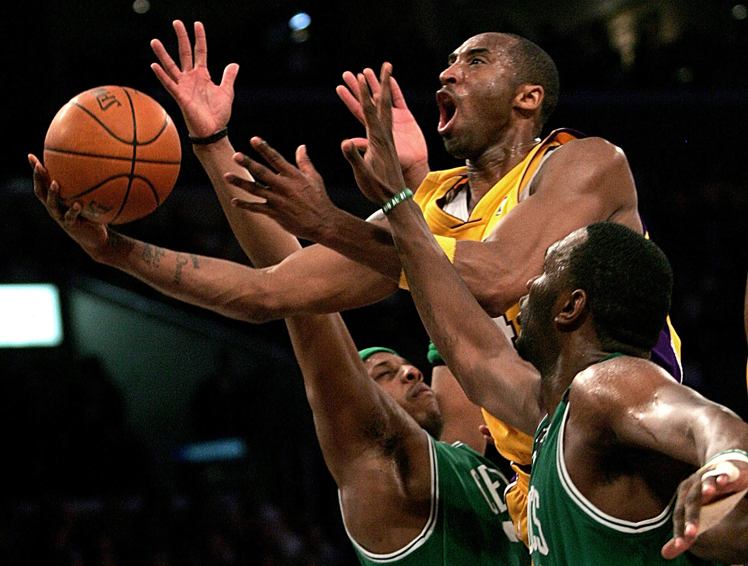 Kobe Bryant goes up for a shot between the Boston Celtics' Paul Pierce and Al Jefferson during an NBA basketball game in Los Angeles on Feb. 23, 2006. (Branimir Kvartuc—AP)