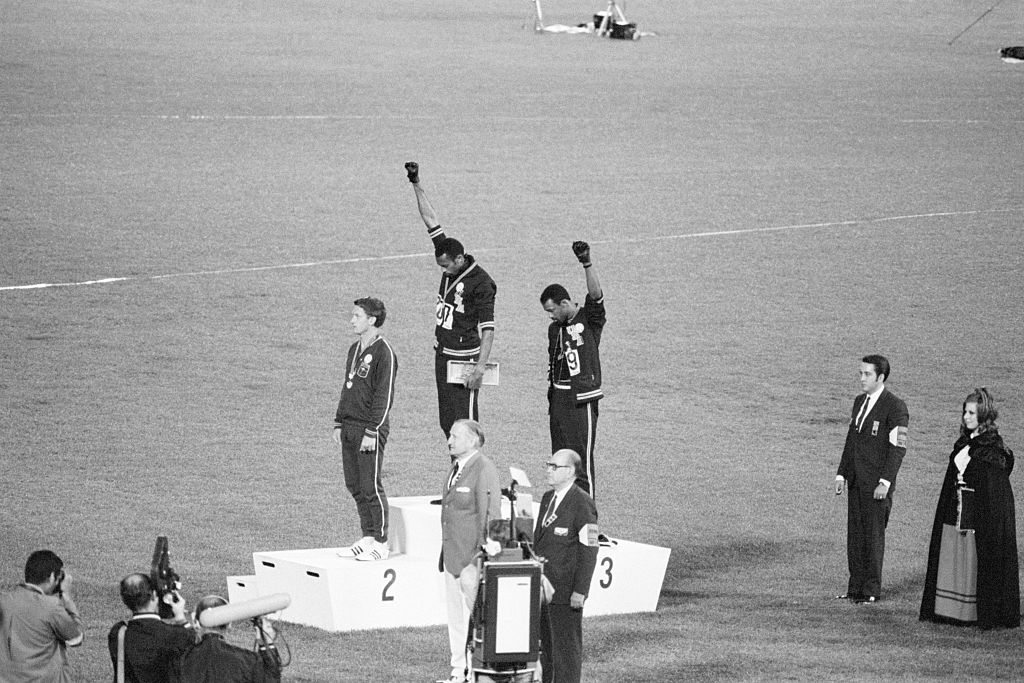 Tommie Smith and John Carlos, gold and bronze medalists in the 200-meter run at the 1968 Olympic Games, engage in a victory stand protest against unfair treatment of black people in the United States. (Bettmann Archive)