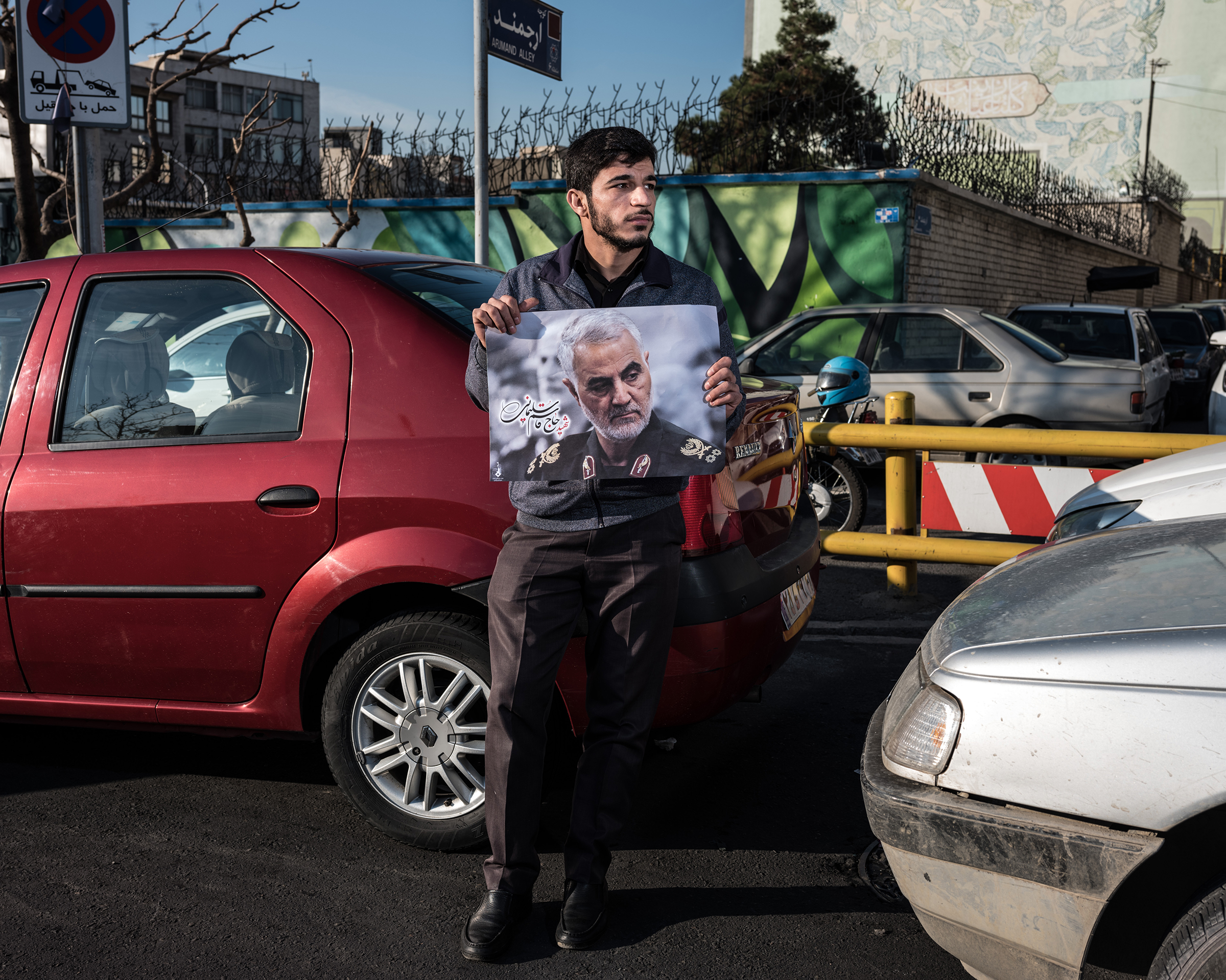 A man holds a poster of Soleimani in traffic in Tehran. (Newsha Tavakolian—Magnum Photos for TIME)