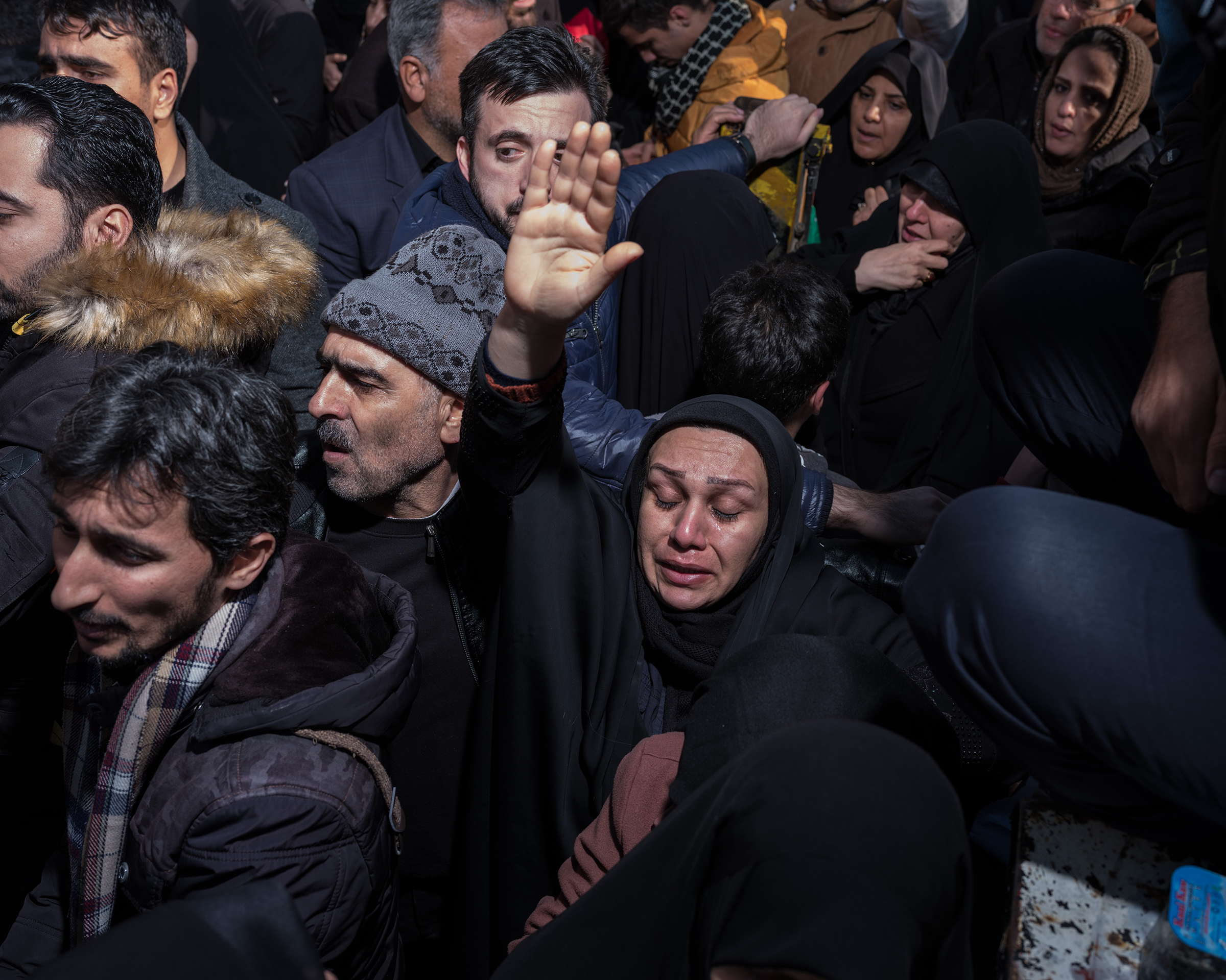 A woman raises her hand in a group of mourners. (Newsha Tavakolian—Magnum Photos for TIME)