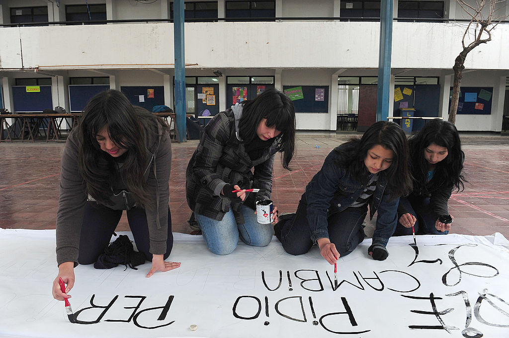 Students from the A-7 public high school for girls paint a banner during a peaceful occupation of the teaching institute in Santiago, on August 14, 2012, during a period of mass student protests. (Claudio Santana/AFP/GettyImages)