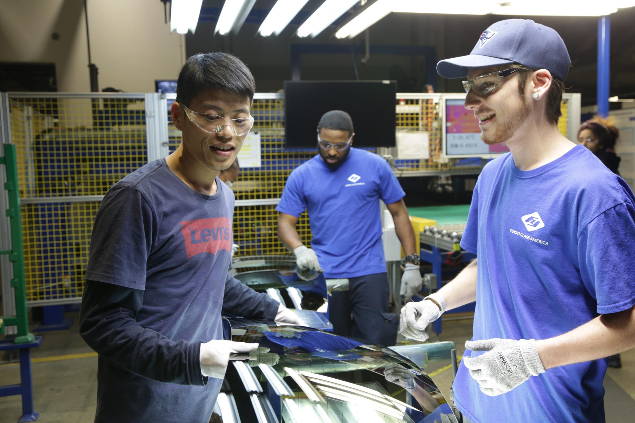 Wong He (left) working with Kenny Taylor (Center) and Jarred Gibson (Right) in the furnace tempering area of the Fuyao factory in the Dayton, Ohio from the film AMERICAN FACTORY
