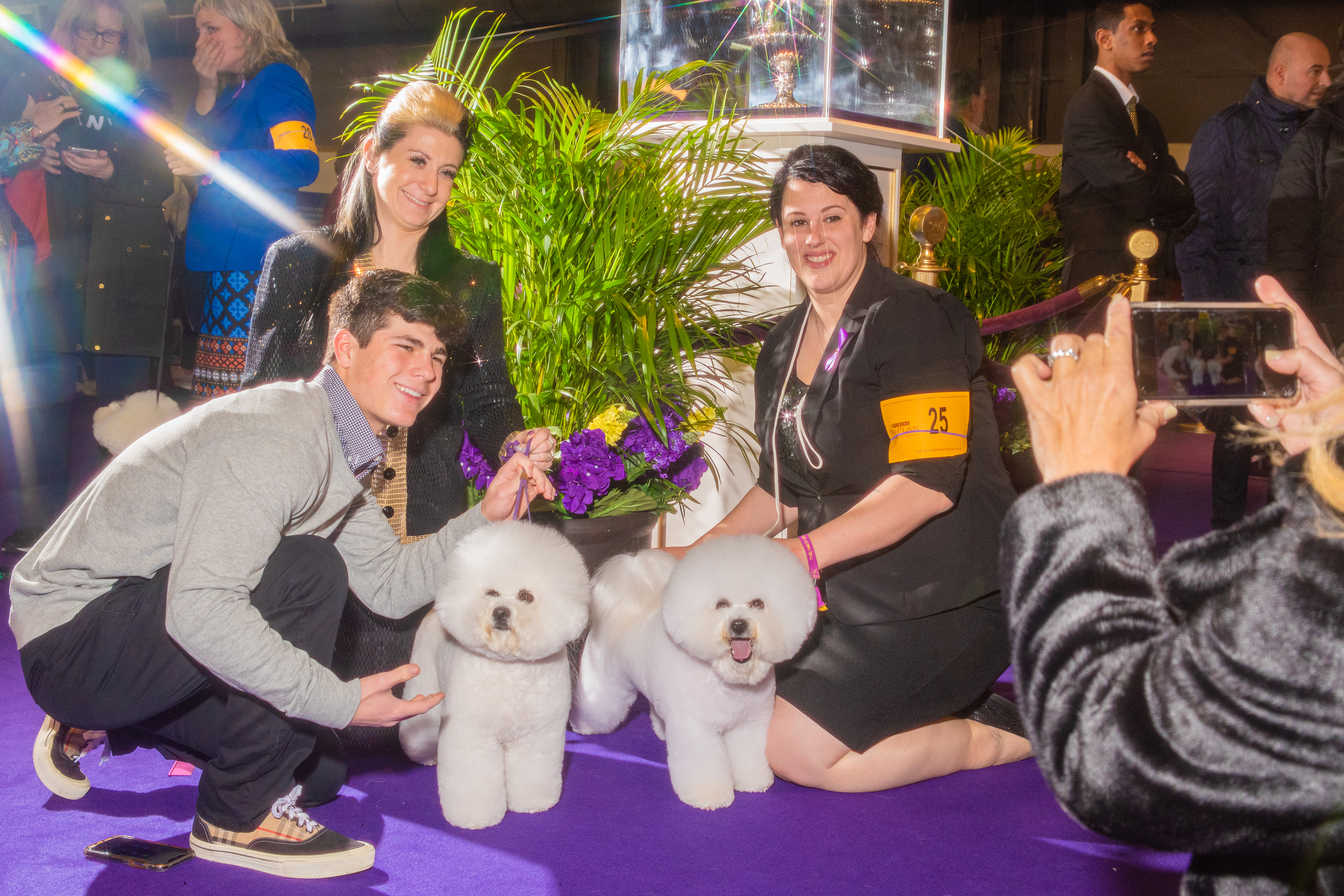 Attendees, photographed using a star filter, pose with two Bichons (Evan Angelastro for TIME)