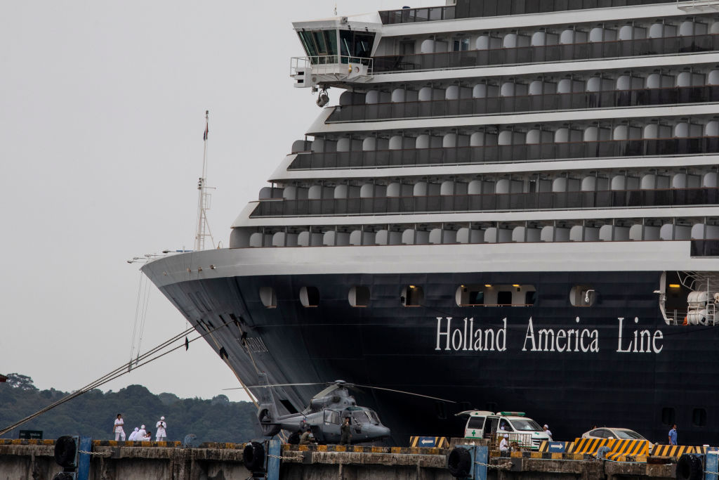 Health officials stand guard outside the MS Westerdam in Sihanoukville, Cambodia on Feb. 17, 2020. After the ship was declared free of coronavirus, one elderly American woman was later found to be infected while transiting in Malaysia. (Photo by Paula Bronstein/Getty Images)