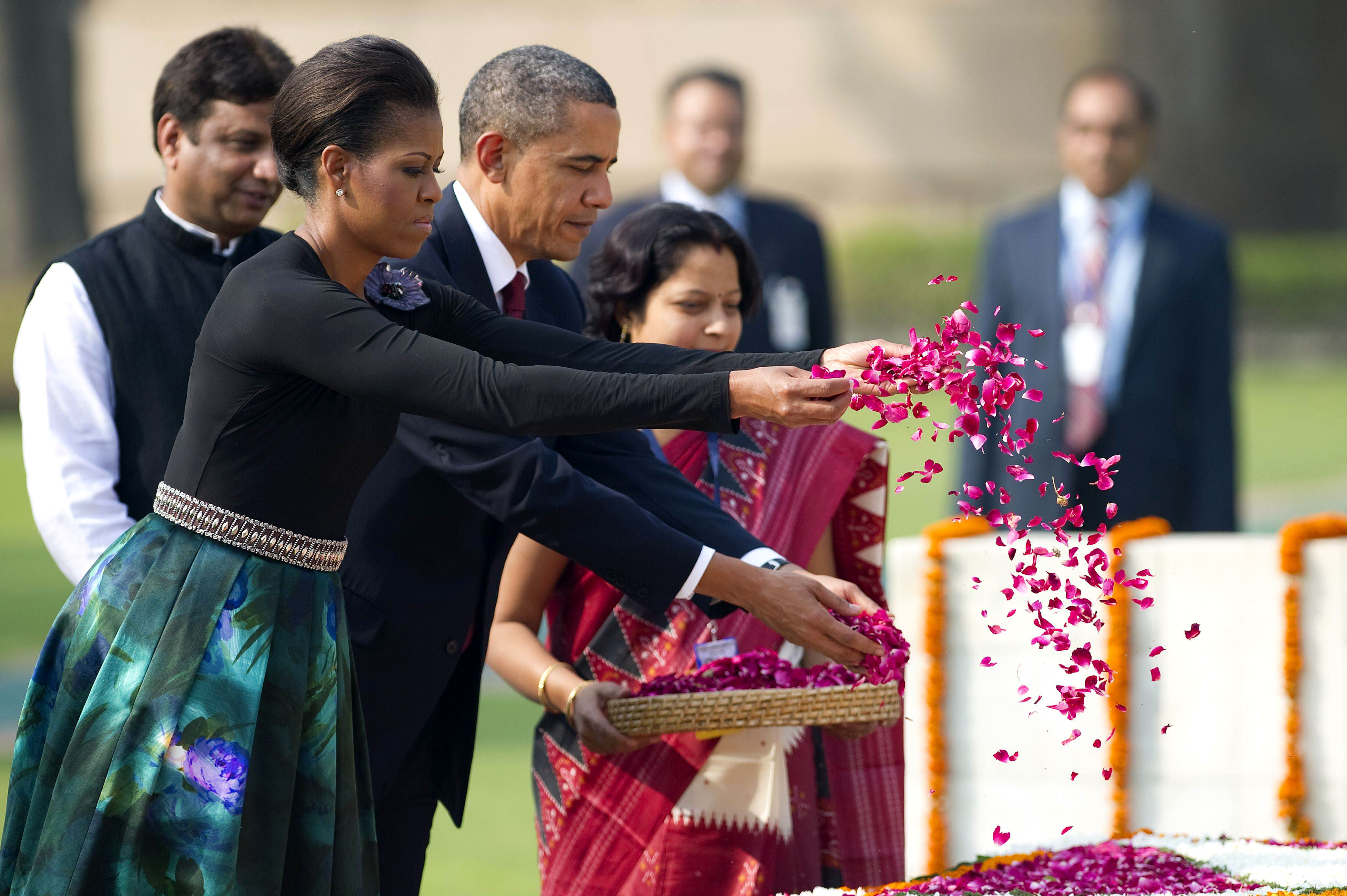U.S. President Barack Obama and First Lady Michelle Obama spread rose petals as they participate in a wreath laying ceremony at Raj Ghat in New Delhi, India, Nov. 8, 2010.