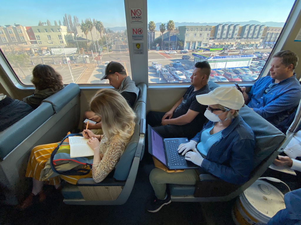 A person wearing a protective mask and gloves rides on a Bay Area Rapid Transit (BART) train car during the morning commute in Oakland, California, on Feb. 27, 2020. (Sam Hall—Bloomberg/Getty Images)