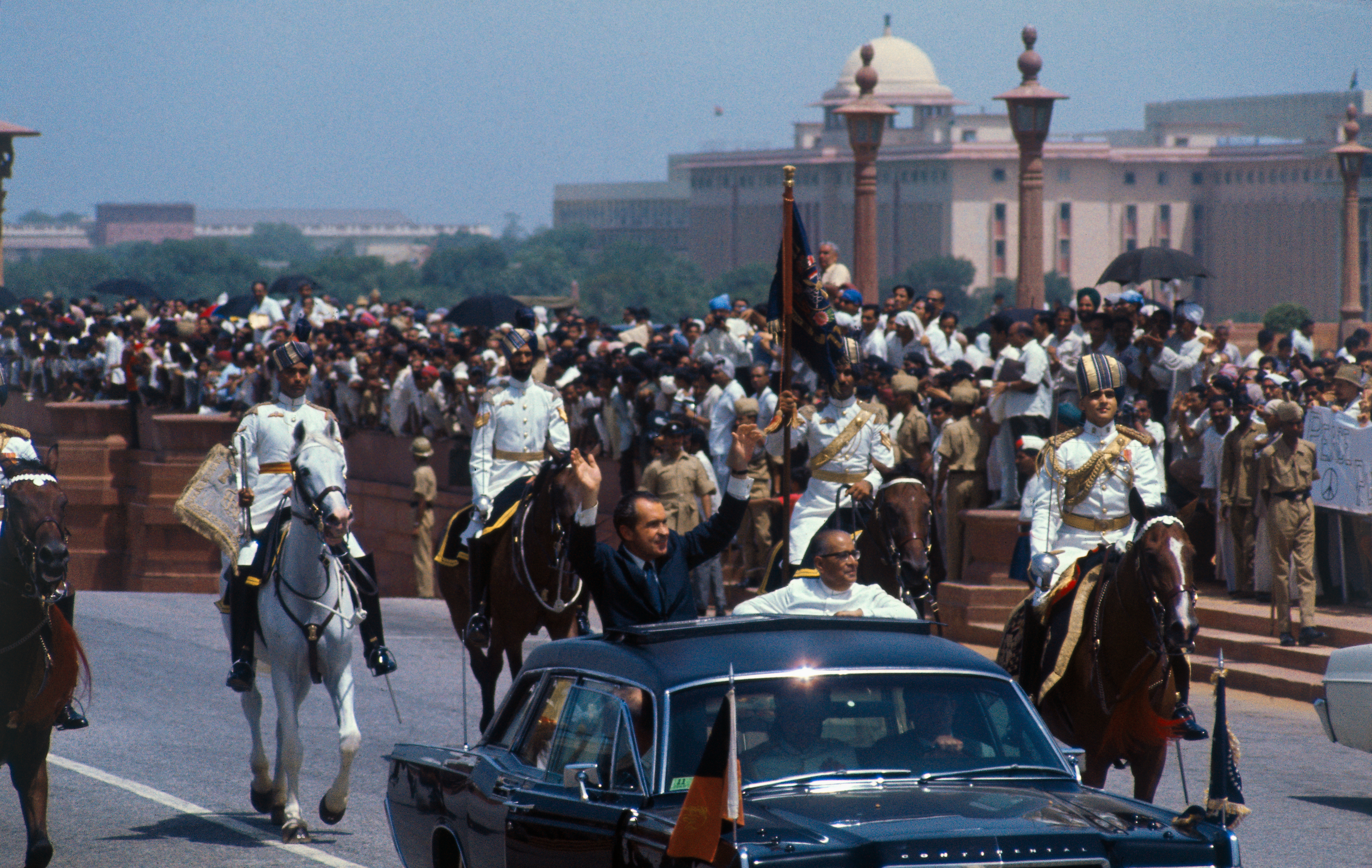 U.S. President Richard Nixon waves to crowds as he rides in open car with the acting president of India, Mohammad Hidyatullah, in motorcade from airport on July 31, 1969. (Bettmann Archive/Getty Images)