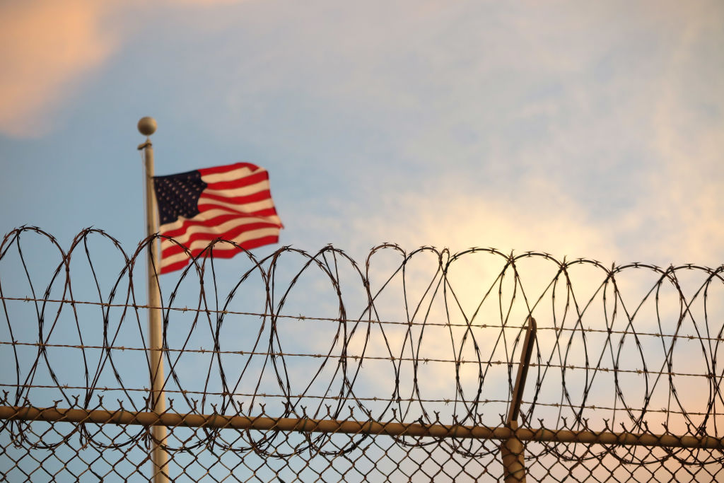 The American flag blows behind a barbed wire fence in the wind in Guantanamo Bay, Cuba on Oct. 16, 2018. (Maren Hennemuth—DPA/Getty Images)