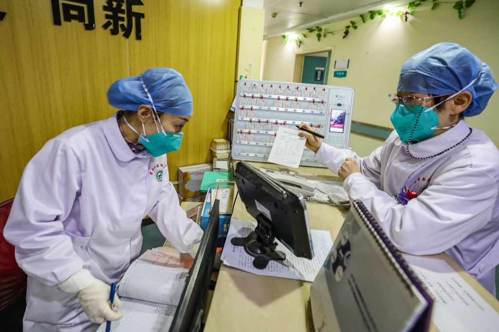 This photo taken on January 30, 2020 shows medical staff members wearing facemasks talking at a hospital in Wuhan in China's central Hubei province, during the virus outbreak in the city. - The World Health Organization declared a global emergency over the new coronavirus, as China reported January 31 the death toll had climbed to 213 with nearly 10,000 infections. (STR/AFP/Getty Images)