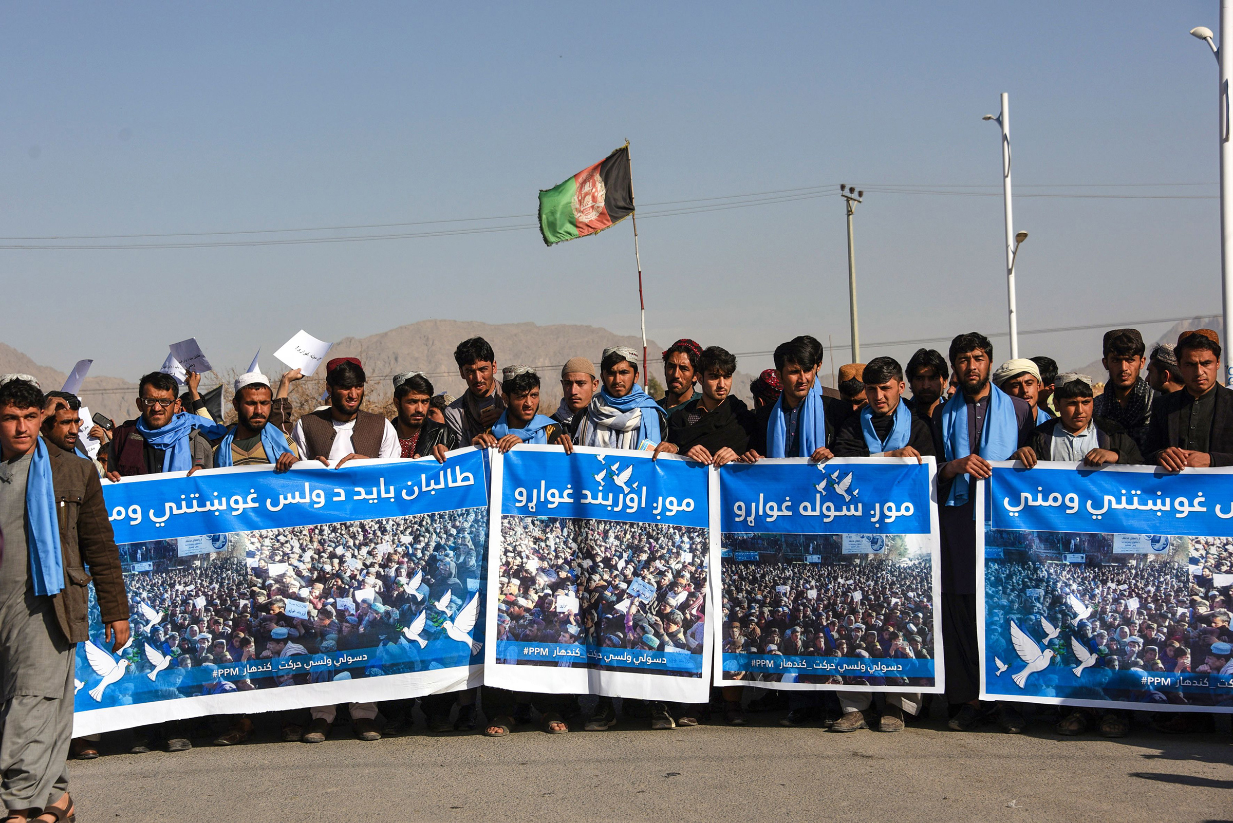 Afghan protesters march for peace and ceasefire as they hold banners in the Kandahar province on Jan. 17, 2019. (Javed Tanveer—AFP via Getty Images)