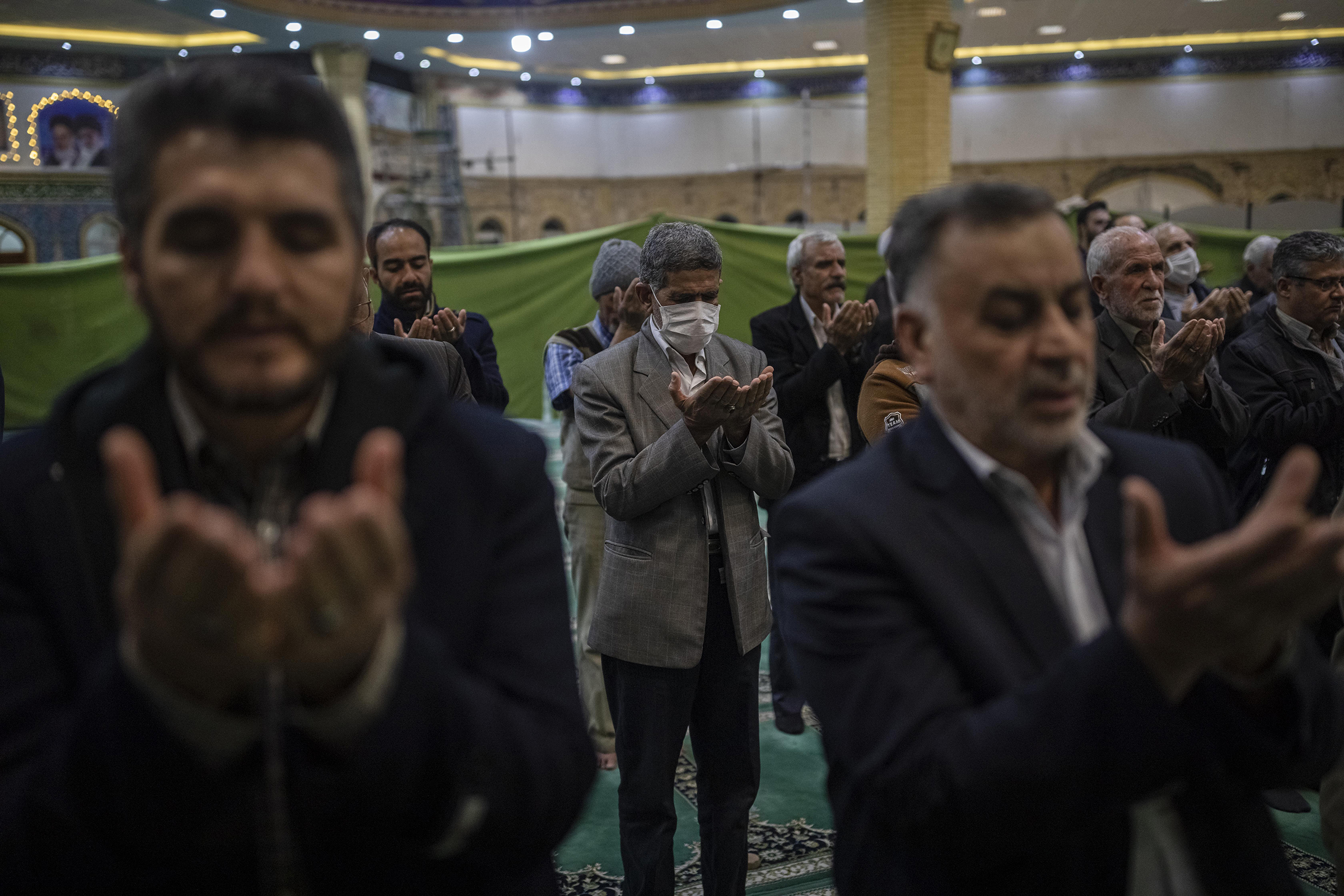 Iranian men are praying with or without a protective face mask in a mosque in Arak, capital of Markazi Province (Sina Yaghoobpoor—Middle East Images/Redux)