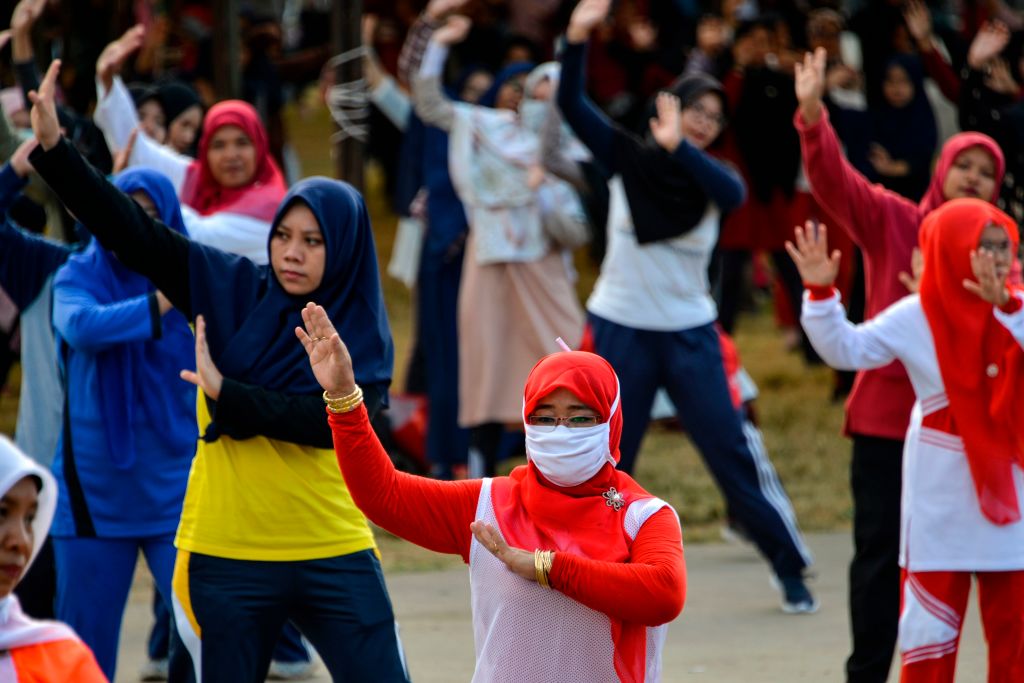 Women wearing face masks exercise at a playground in Banda Aceh, Indonesia on Feb. 2, 2020. (CHAIDEER MAHYUDDIN—AFP/Getty Images)