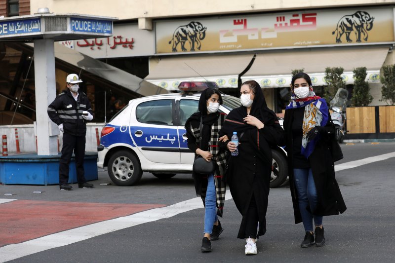 A policeman and pedestrians wear masks in Tehran, Iran, on Feb. 23, 2020.