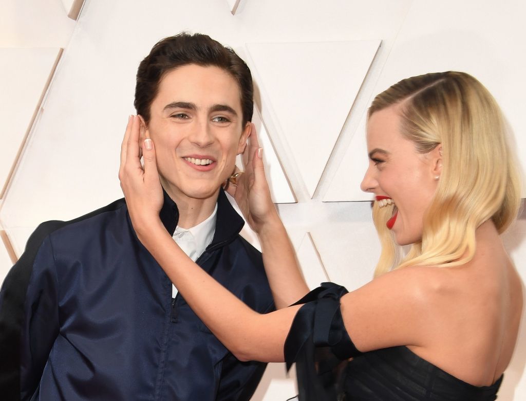 Australian actress Margot Robbie plays with US-French actor Timothee Chalamet as they arrive for the 92nd Oscars at the Dolby Theatre in Hollywood, California on February 9, 2020. (AFP via Getty Images)
