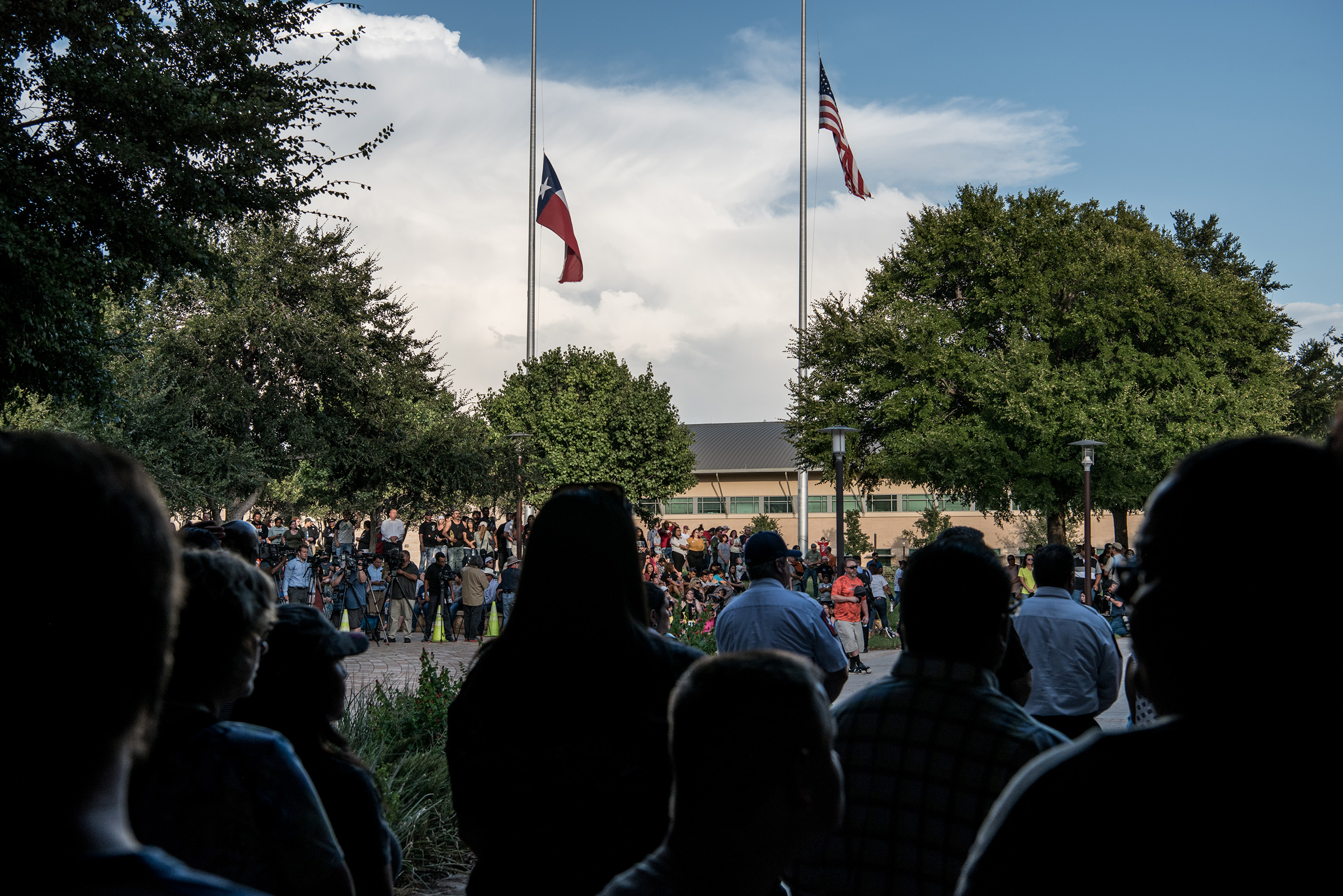Flags fly at half mast over a prayer vigil at the University of Texas of the Permian Basin for the victims of a mass shooting in Odessa, TX, on Sept. 1, 2019. (Cengiz Yar—Getty Images)