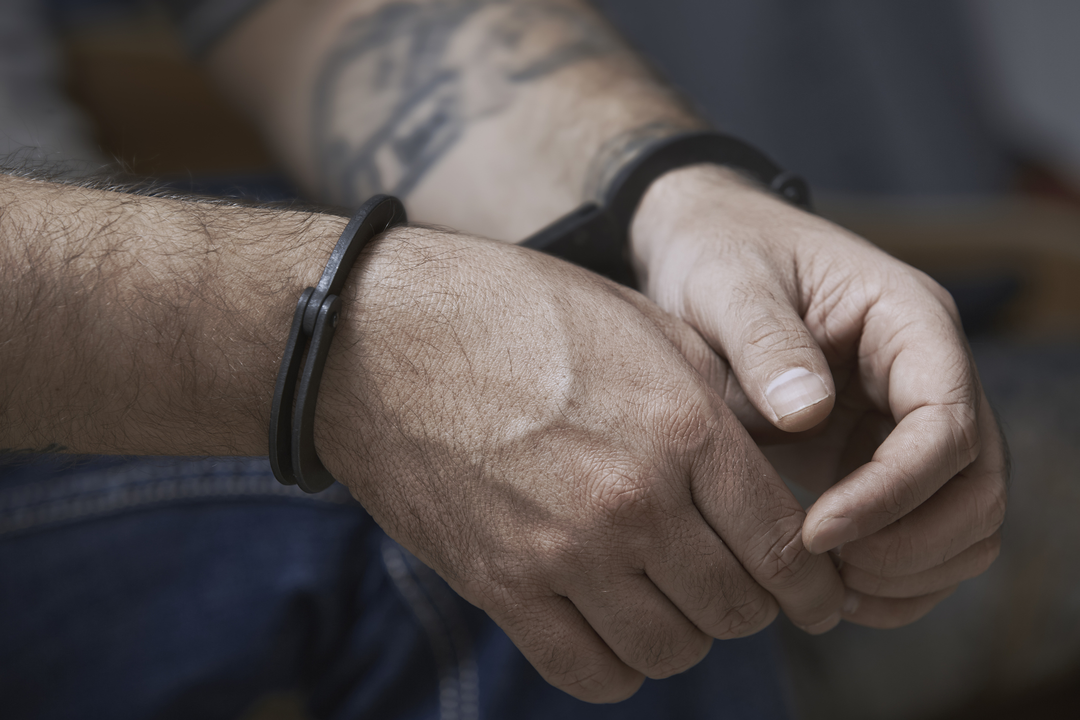 A cropped image of a man in handcuffs. (Cavan Images—Getty Images)