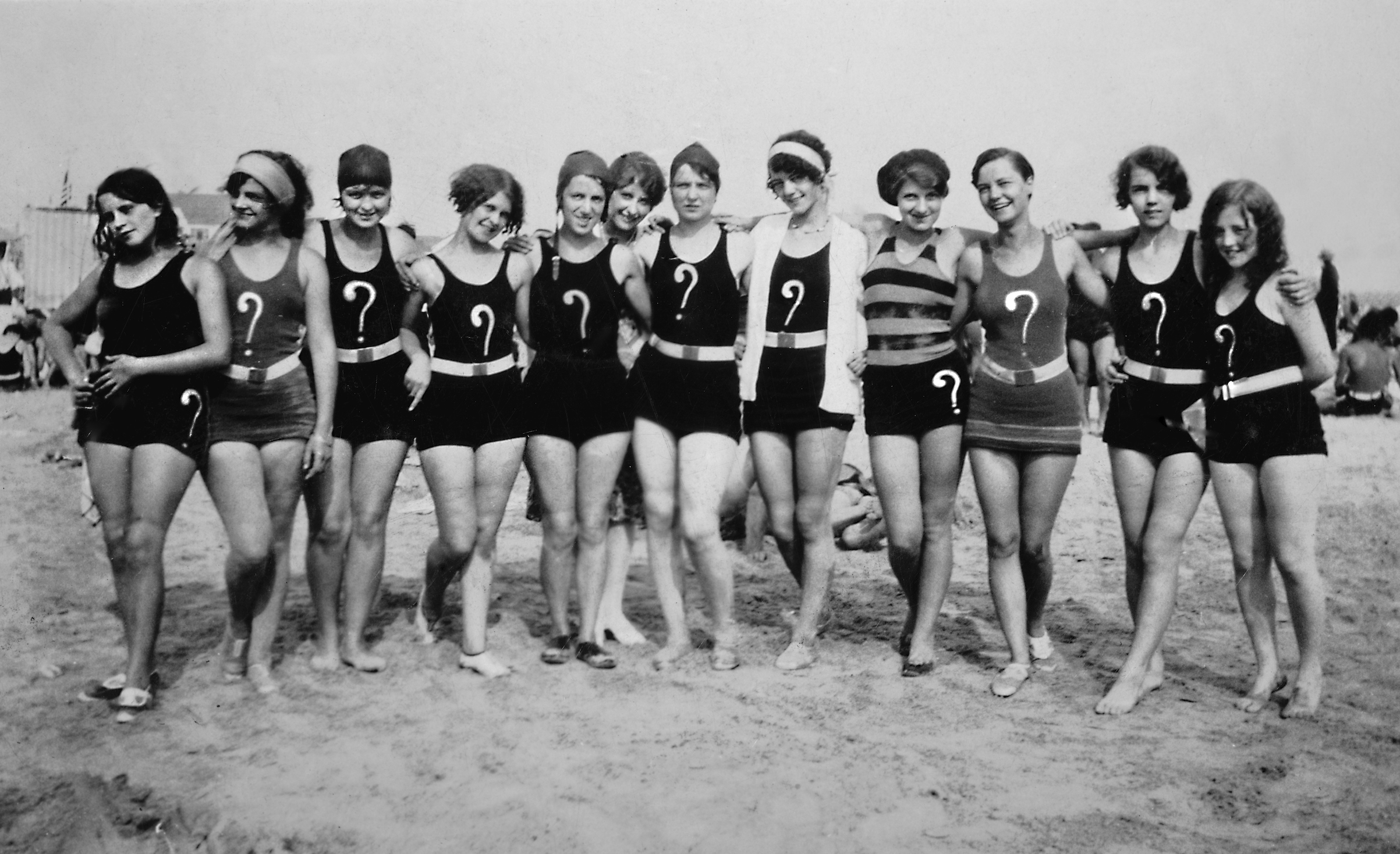 A group of flappers with question marks on their swim suits pose together on the beach, ca. 1925. (Corbis via Getty Images)