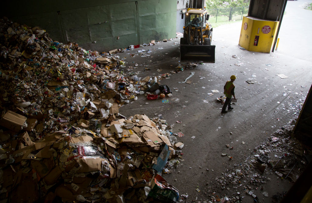 Recycling material is pushed into mounds before being sorted at an Ecomaine facility on Thursday, May 3, 2018. (Derek Davis/Portland Portland Press Herald via Getty Images)